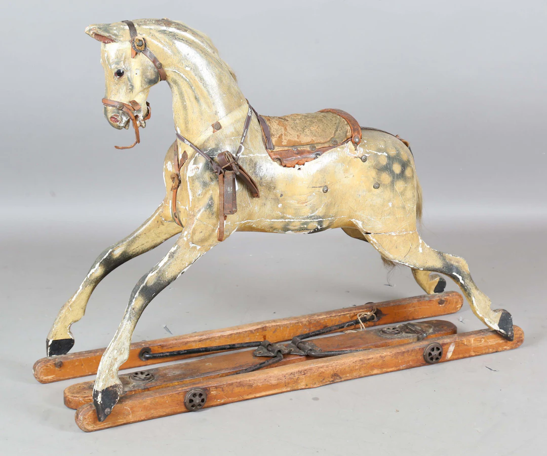 A Victorian carved wooden and painted rocking horse, raised on part