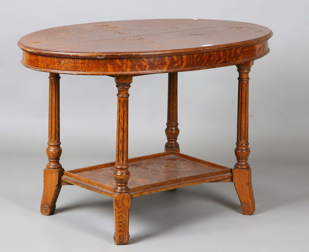 An Edwardian oak oval two-tier occasional table, on fluted legs, height
