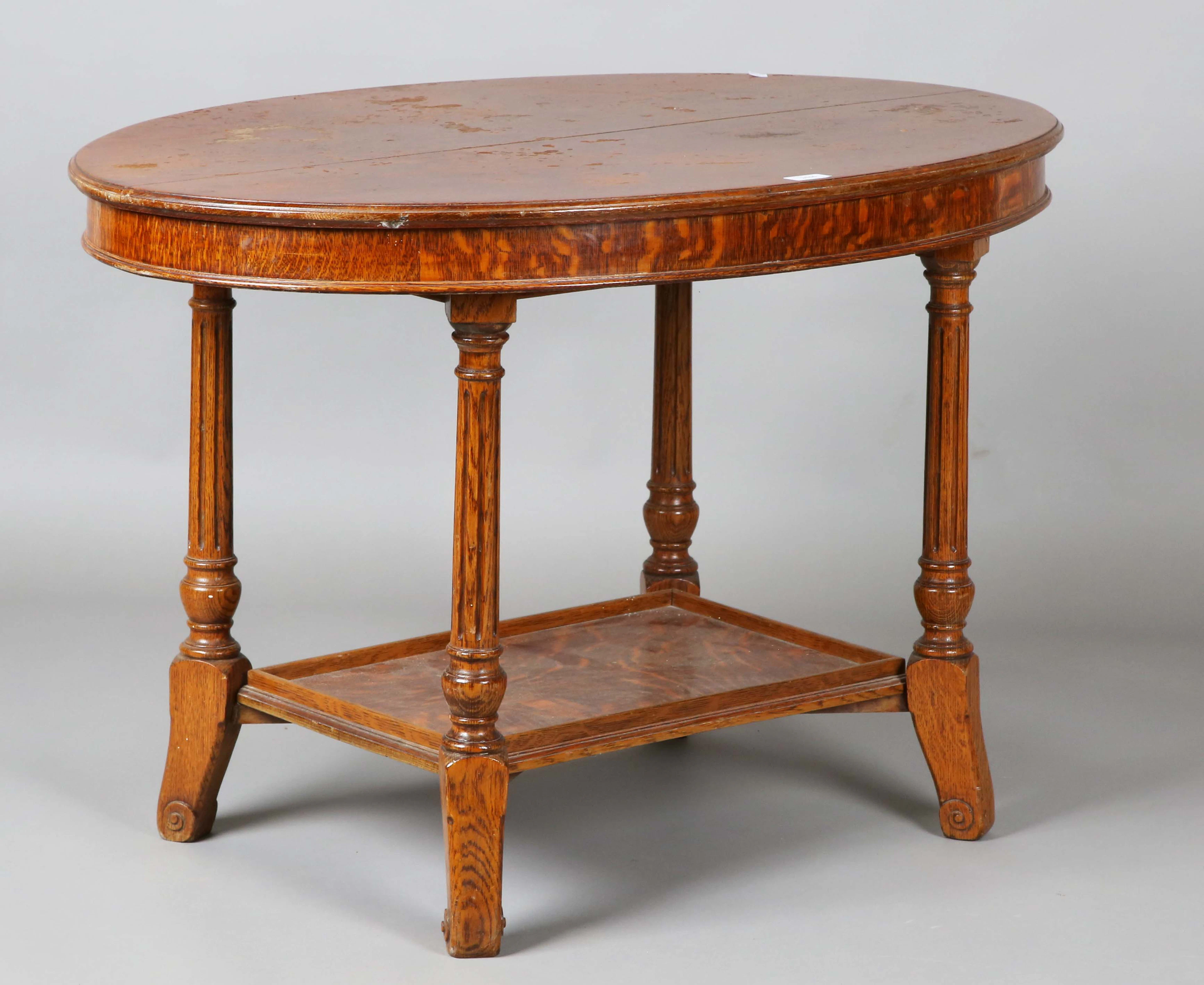 An Edwardian oak oval two-tier occasional table, on fluted legs, height