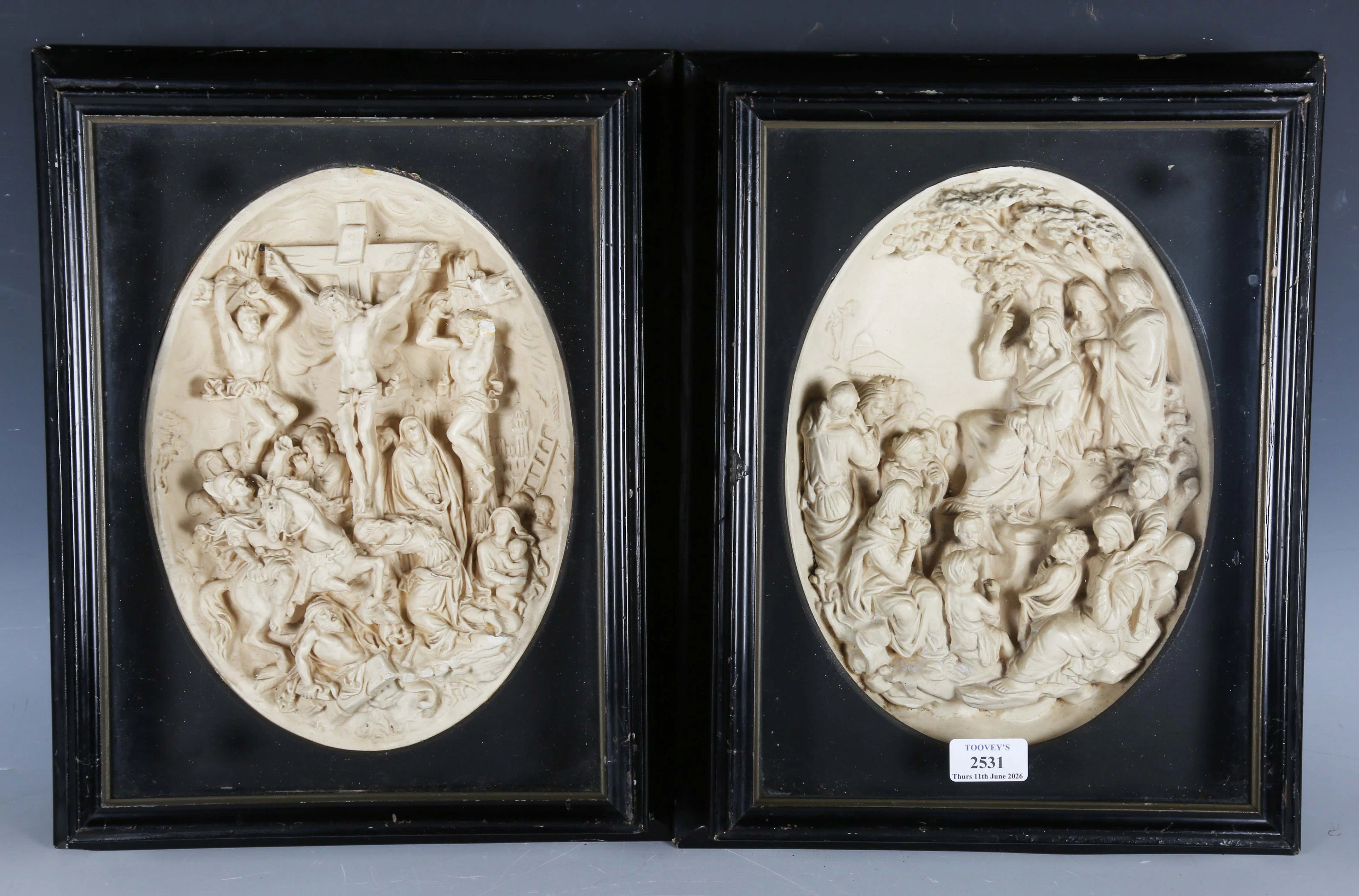 A pair of early 20th century cast composition oval plaques, each depicting