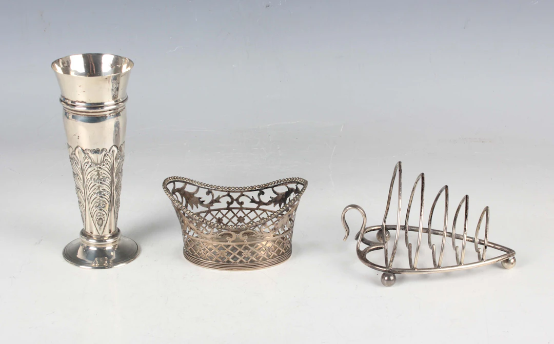 A late Victorian silver heart shaped four-division toast rack on ball