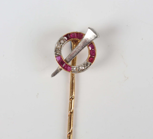 A gold, ruby and diamond stickpin, the finial in a hoop design, mounted
