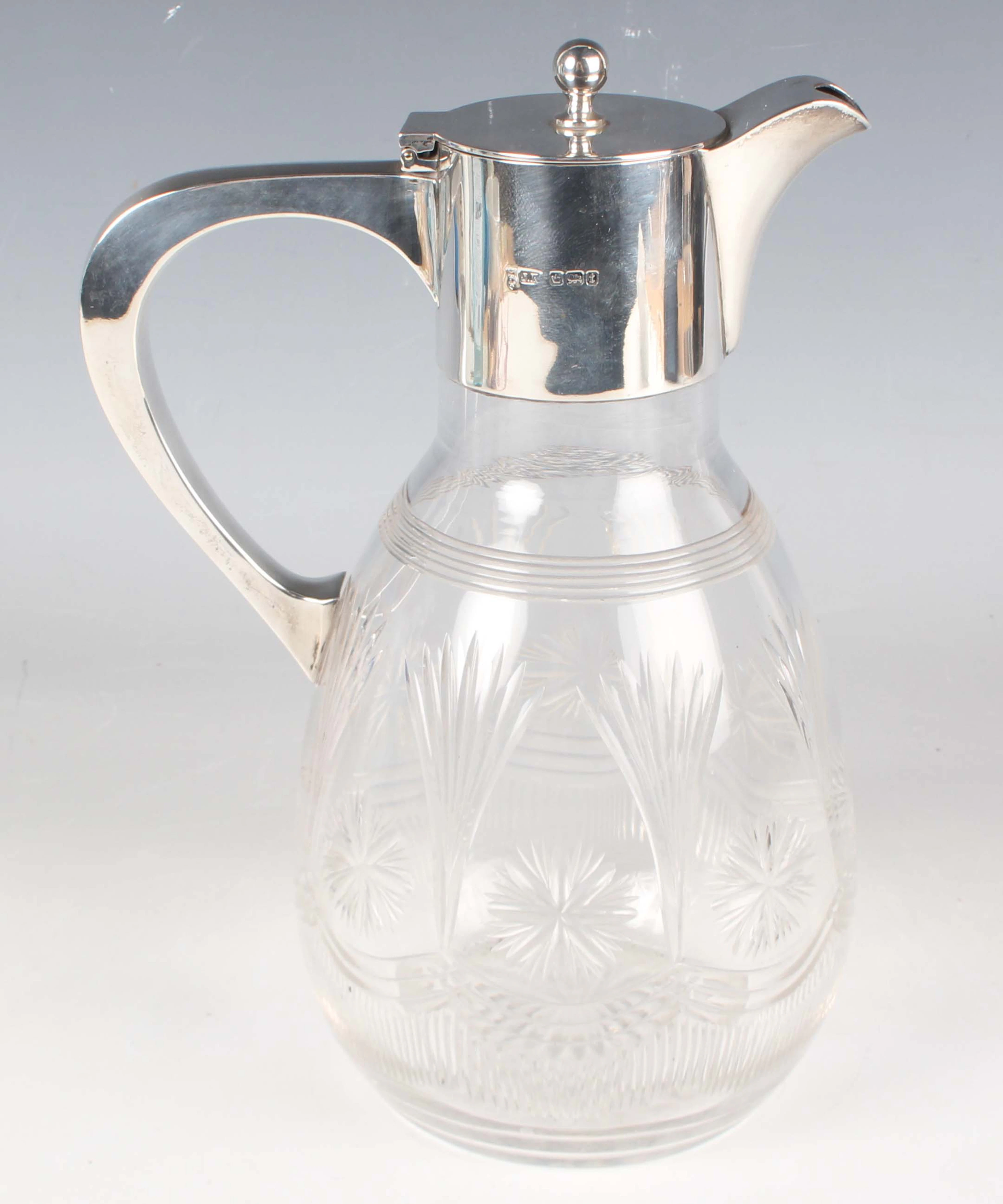 A George V silver mounted cut glass claret jug, the cylindrical neck