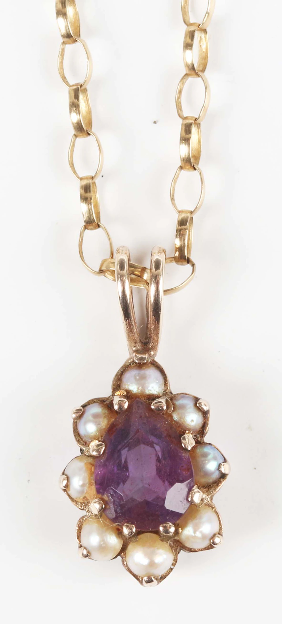 A 9ct gold amethyst and half-pearl pendant, claw set with the pear