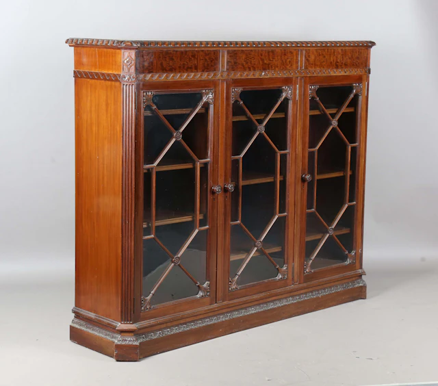 An early 20th century reproduction mahogany glazed bookcase by Waring