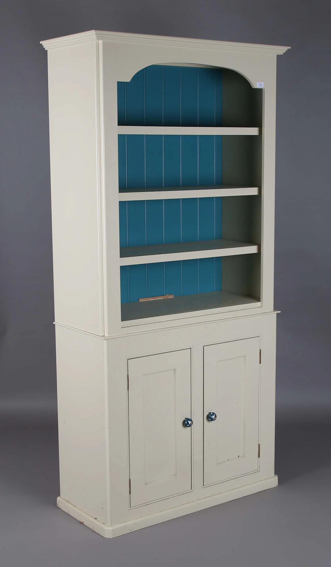 A modern cream painted bookcase cabinet, fitted with three shelves