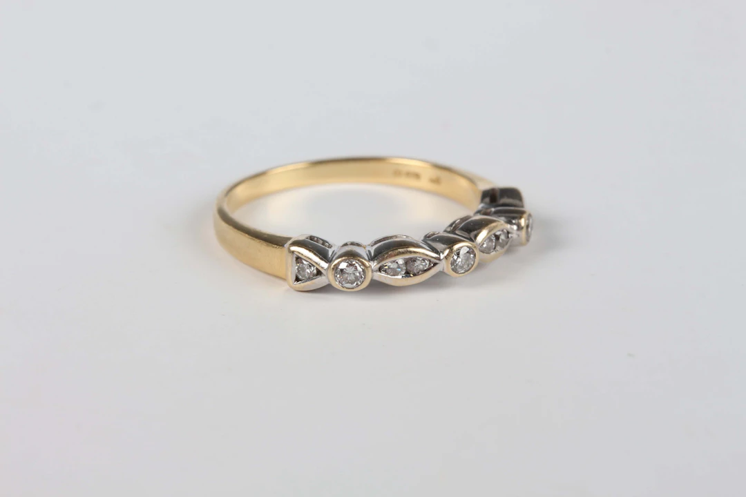 An 18ct gold and diamond half eternity ring, mounted with circular