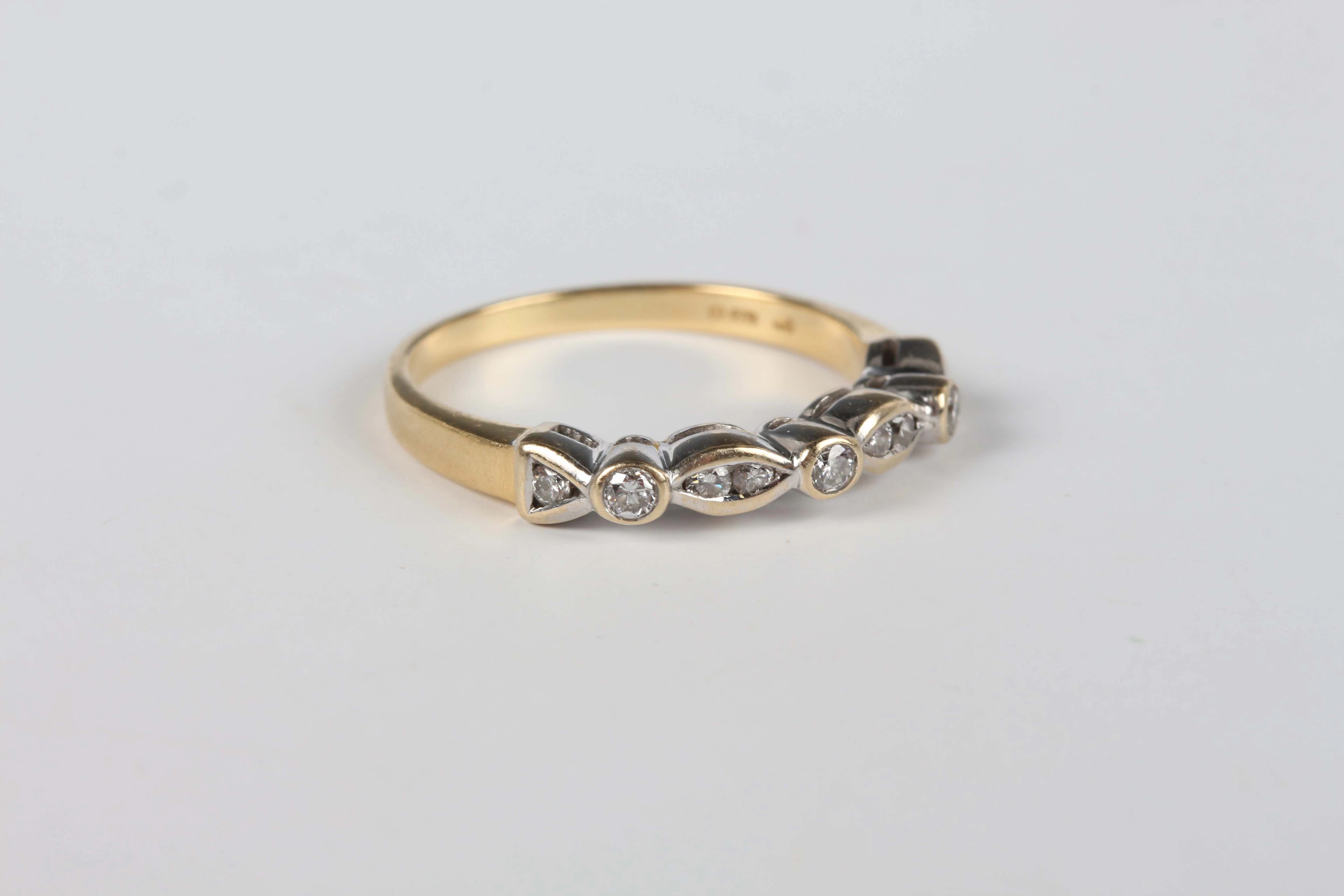 An 18ct gold and diamond half eternity ring, mounted with circular