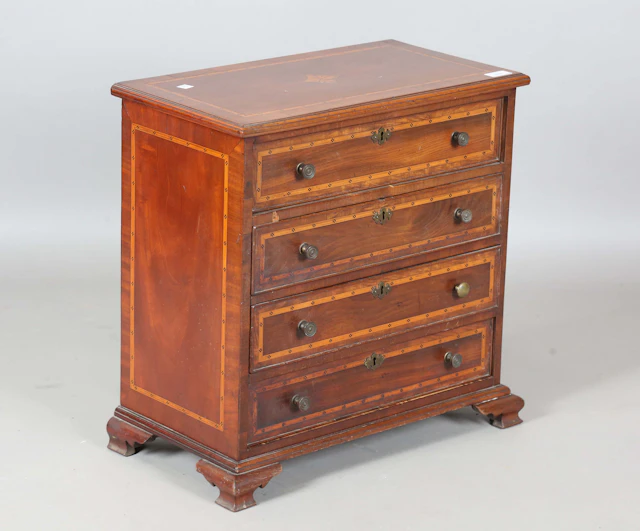An Edwardian mahogany table-top chest of four drawers with chequer