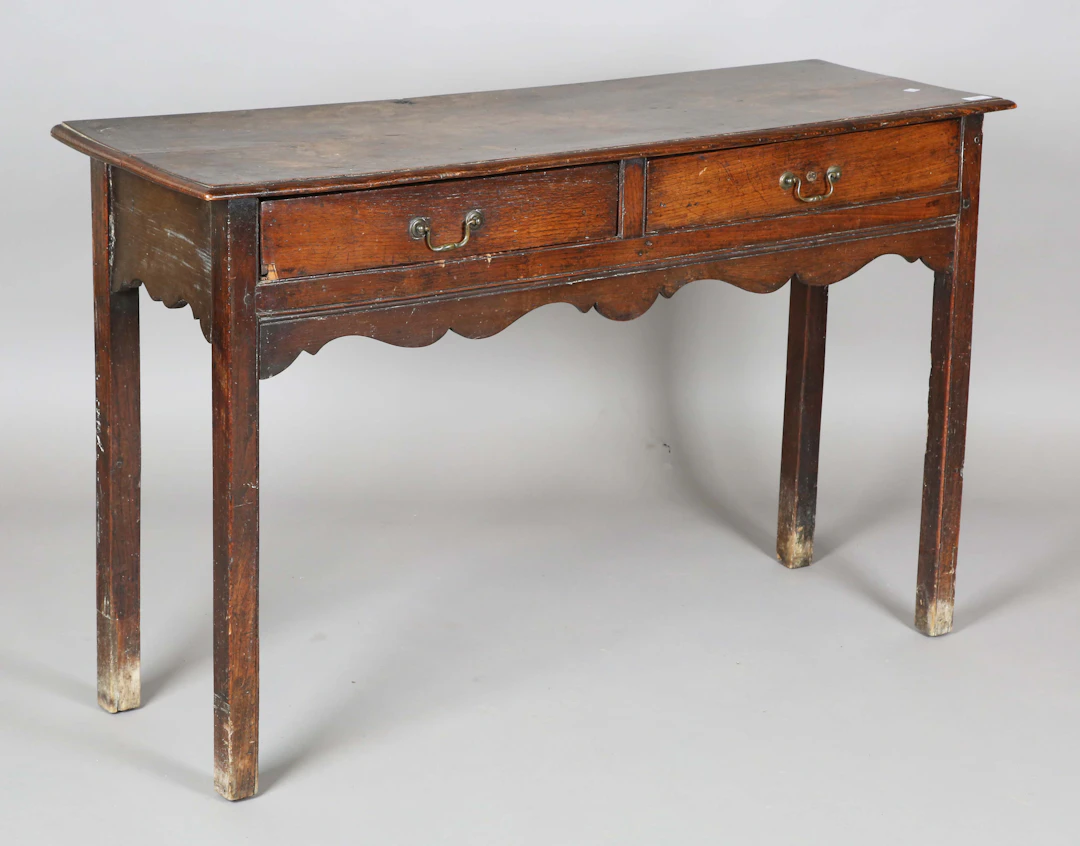 A George III provincial oak side table, fitted with two drawers, on