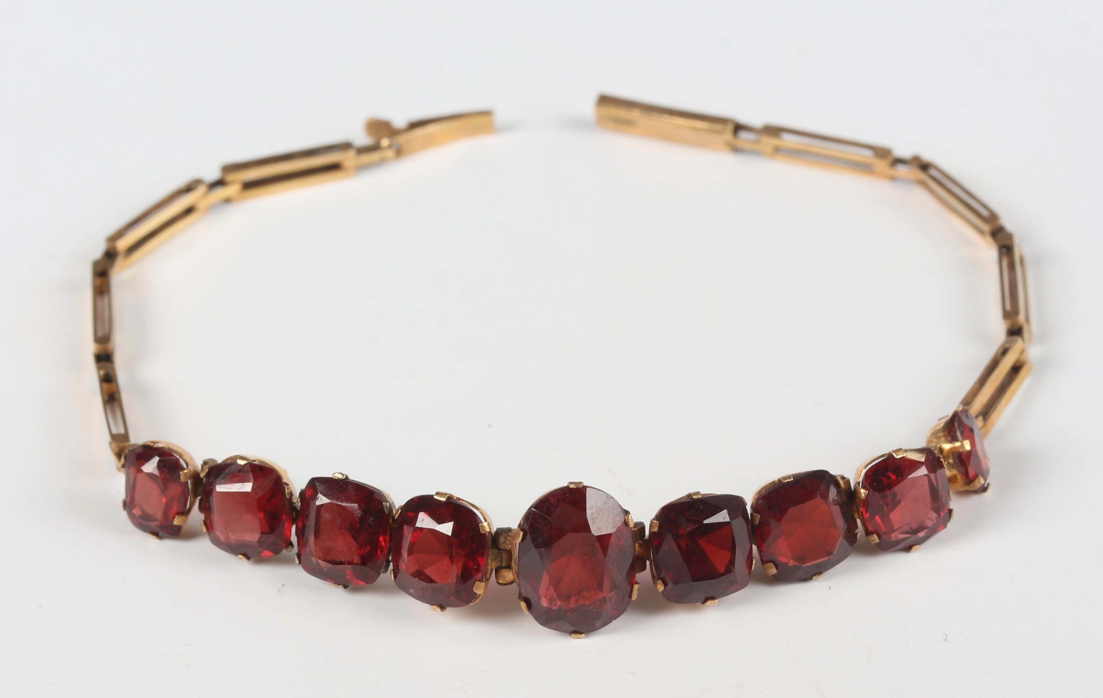 A gold and garnet bracelet, mounted with a row of nine graduating