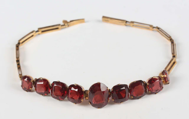 A gold and garnet bracelet, mounted with a row of nine graduating
