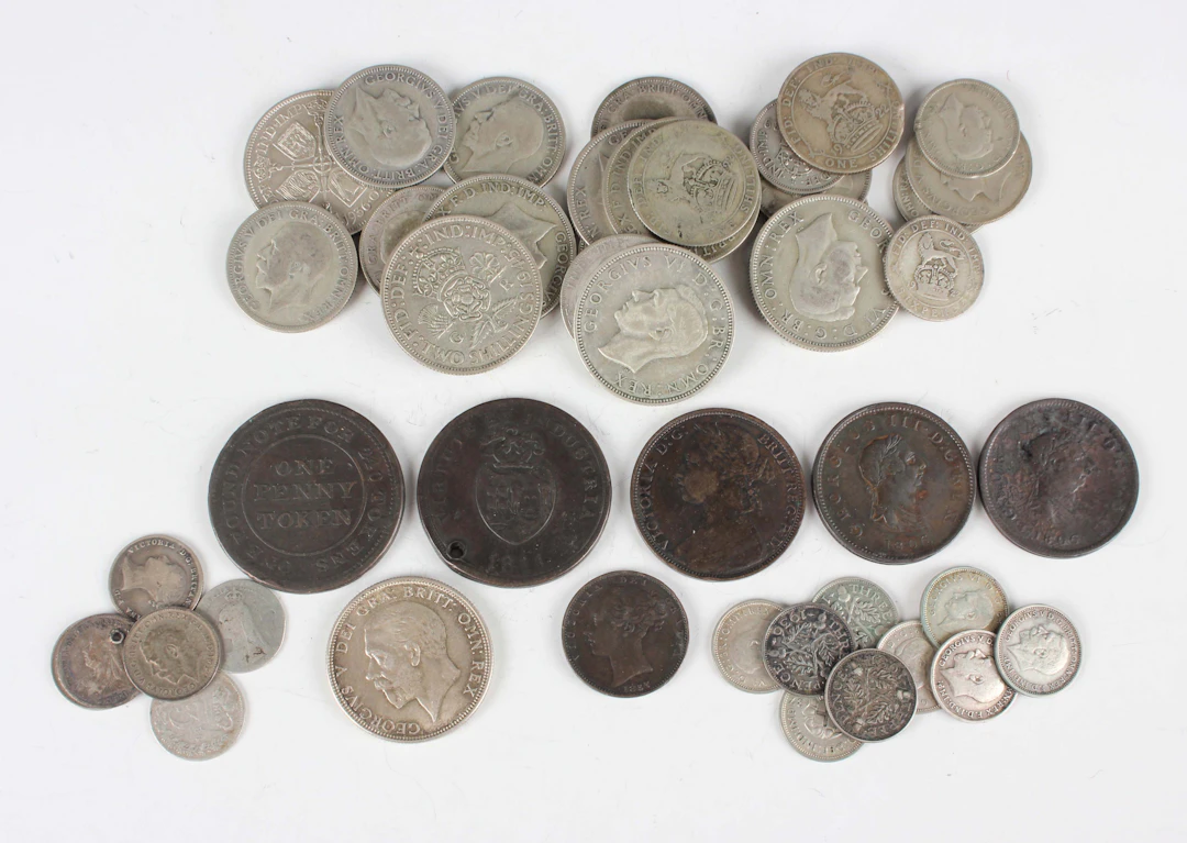 A collection of British coins and paranumismatic items, including