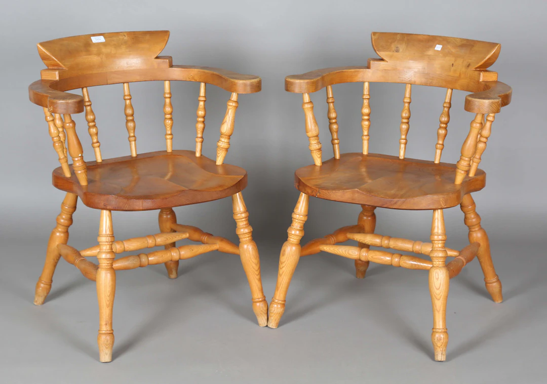 A pair of 20th century elm tub back captains' Windsor chairs with