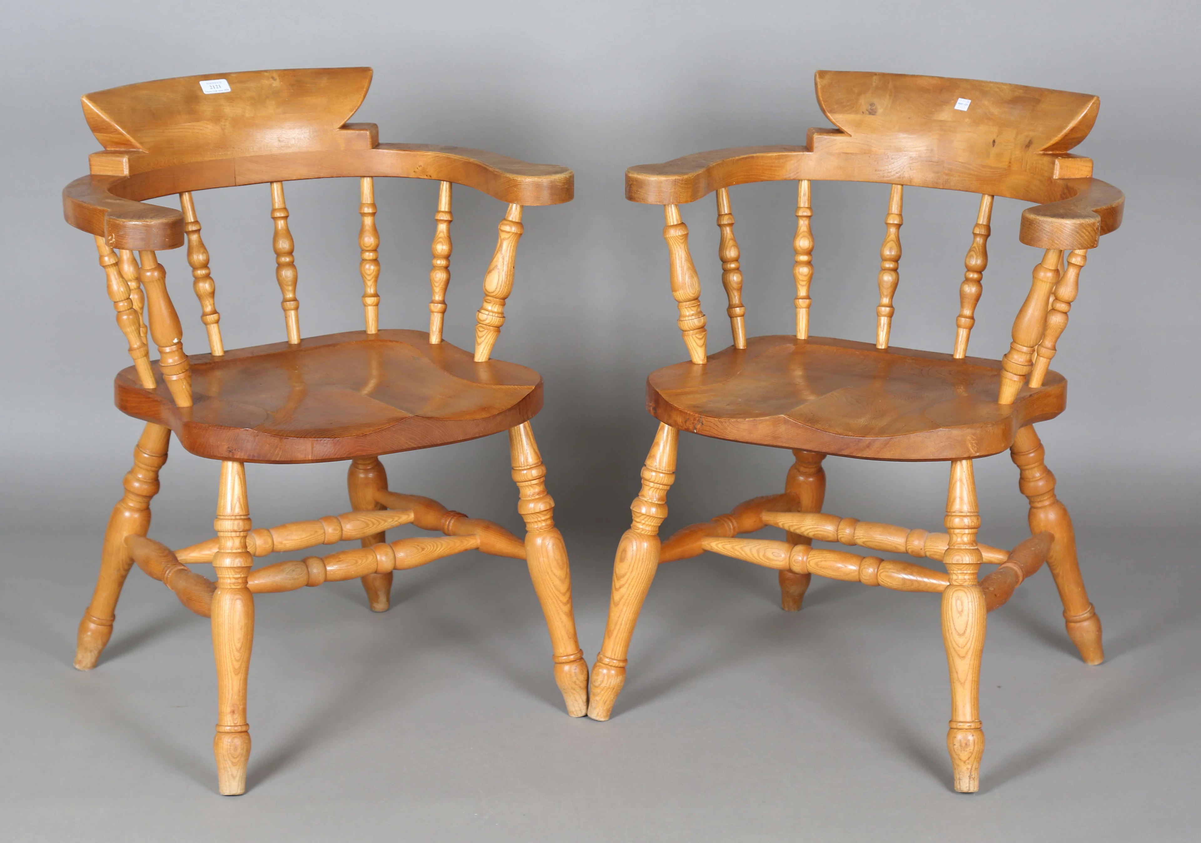 A pair of 20th century elm tub back captains' Windsor chairs with