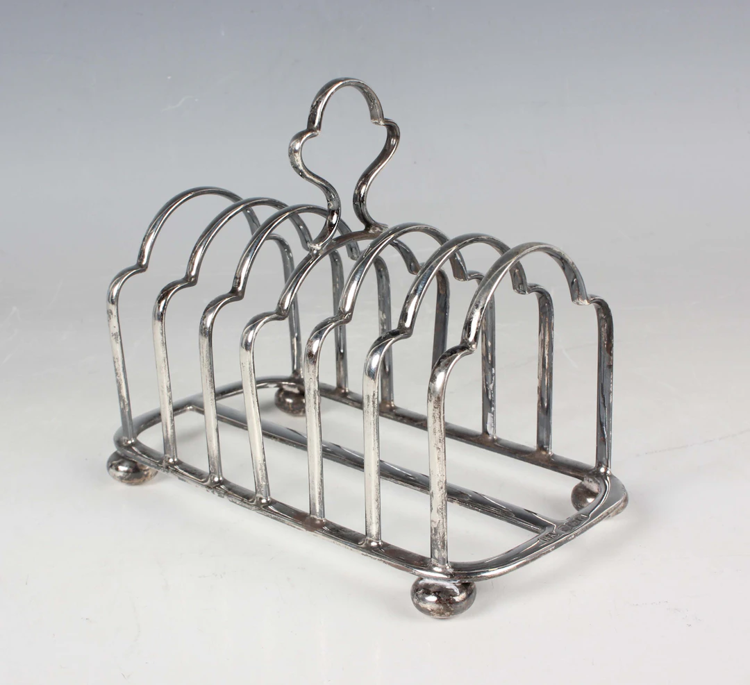 A George V silver six-division toast rack with central handle and