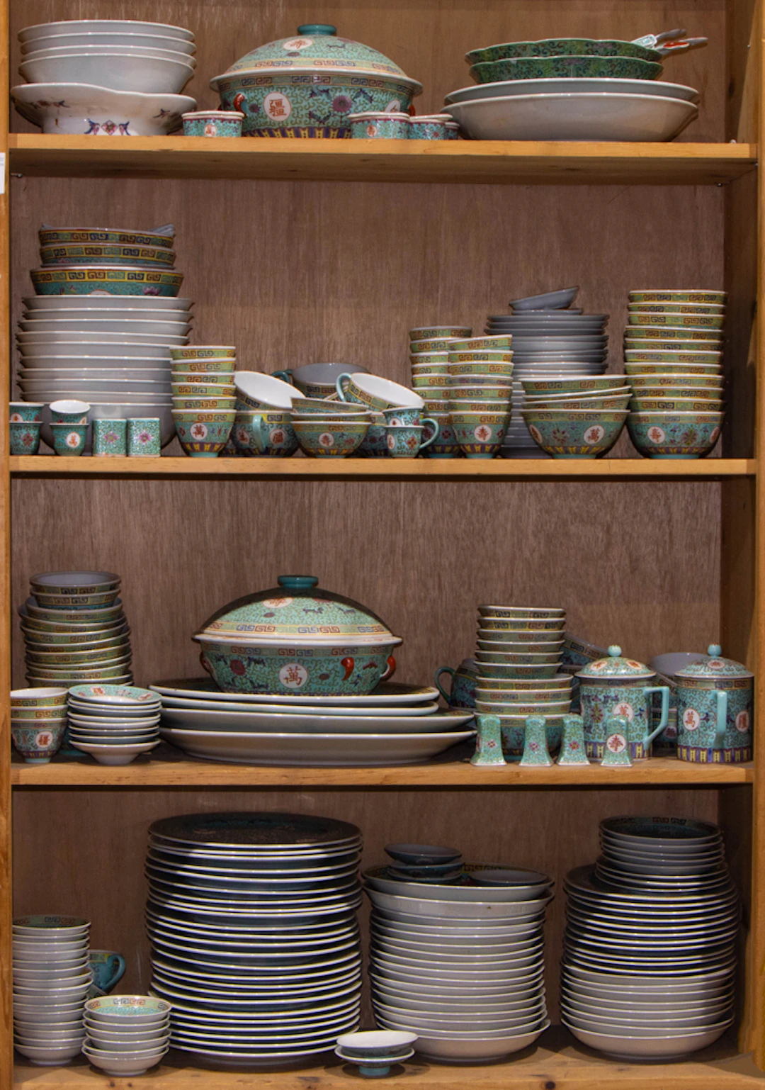 Four shelves of Chinese famille rose turquoise ground dinner service