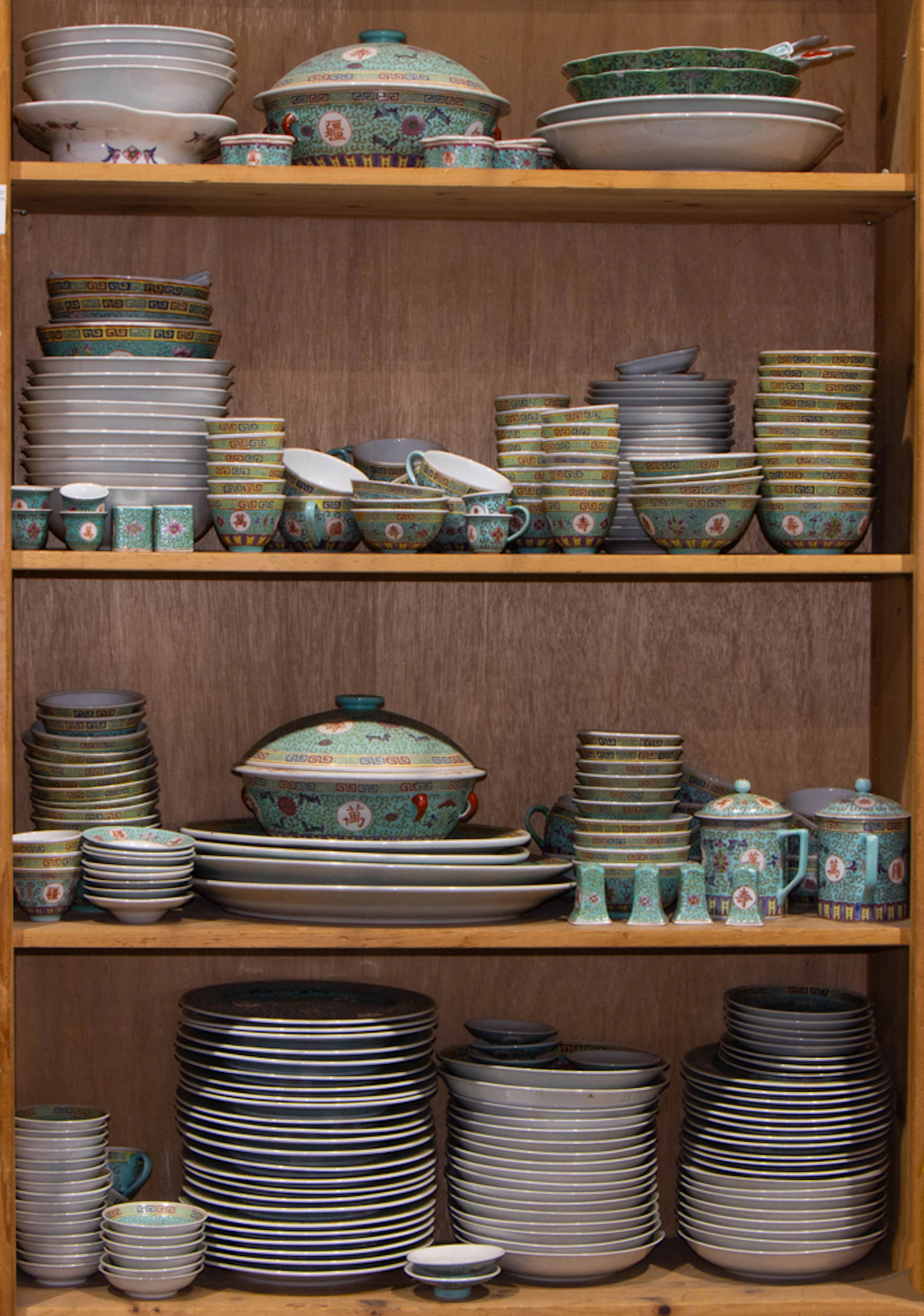 Four shelves of Chinese famille rose turquoise ground dinner service