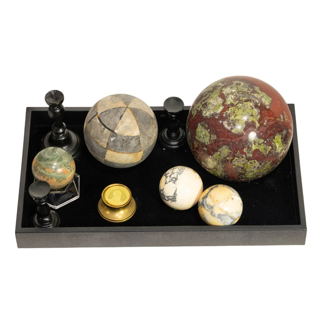 A collection of five stone spheres including a large bloodstone
