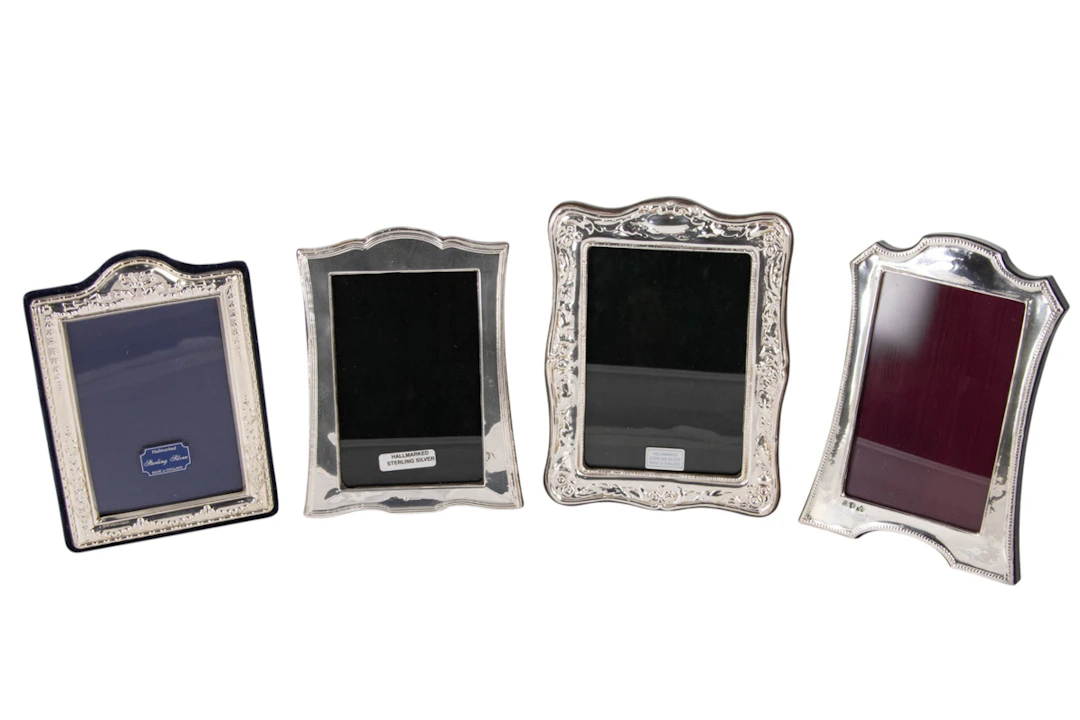 A group of four English silver faced vertical photo frames