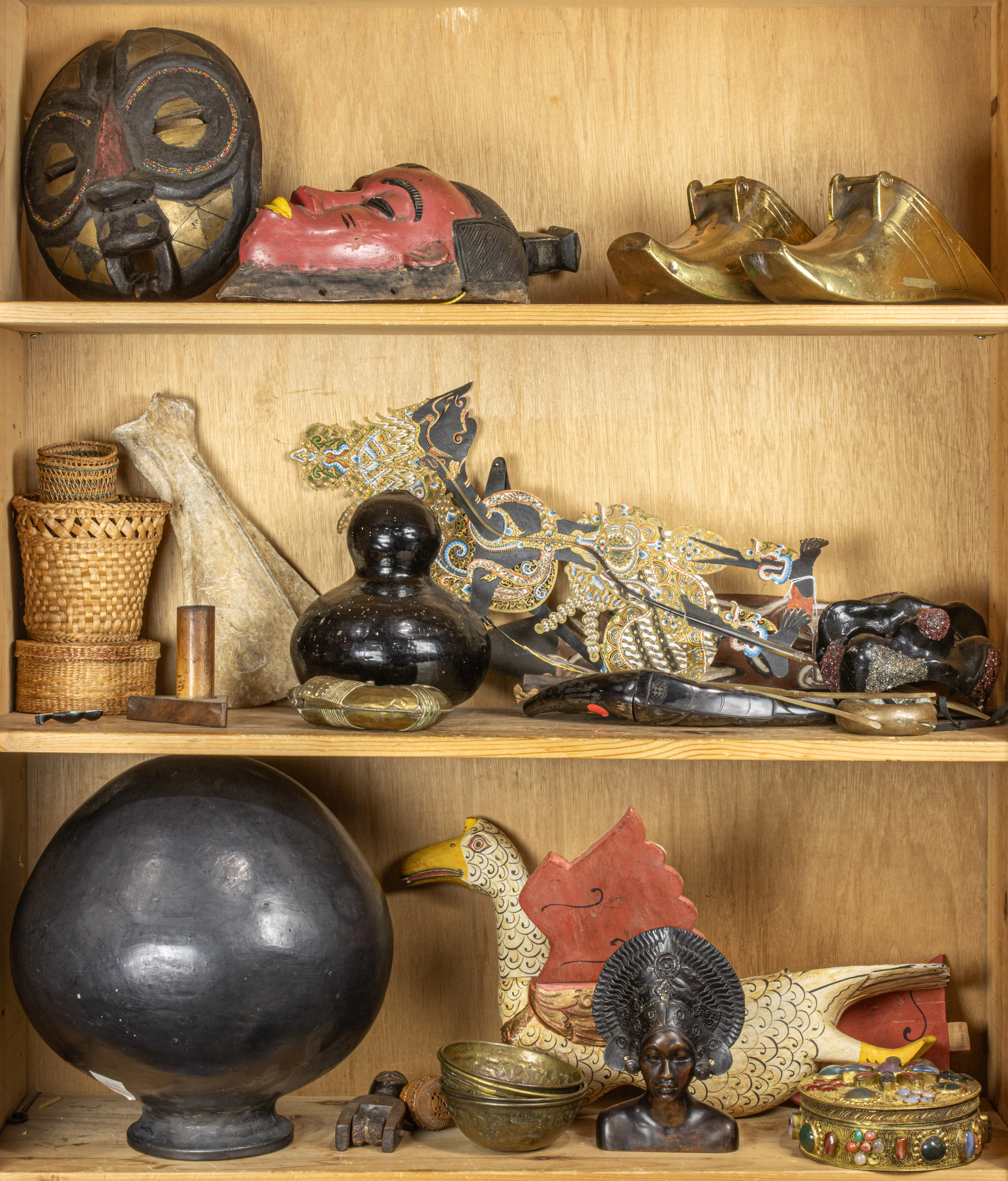 Three shelves of ethnographic and international decorative arts in wood