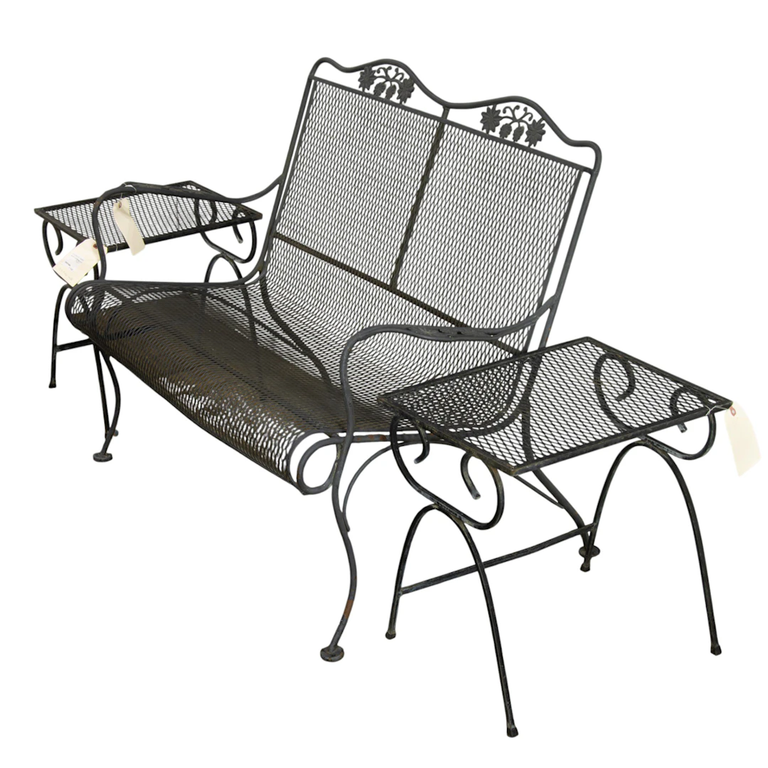 A three-piece wrought iron outdoor furniture set