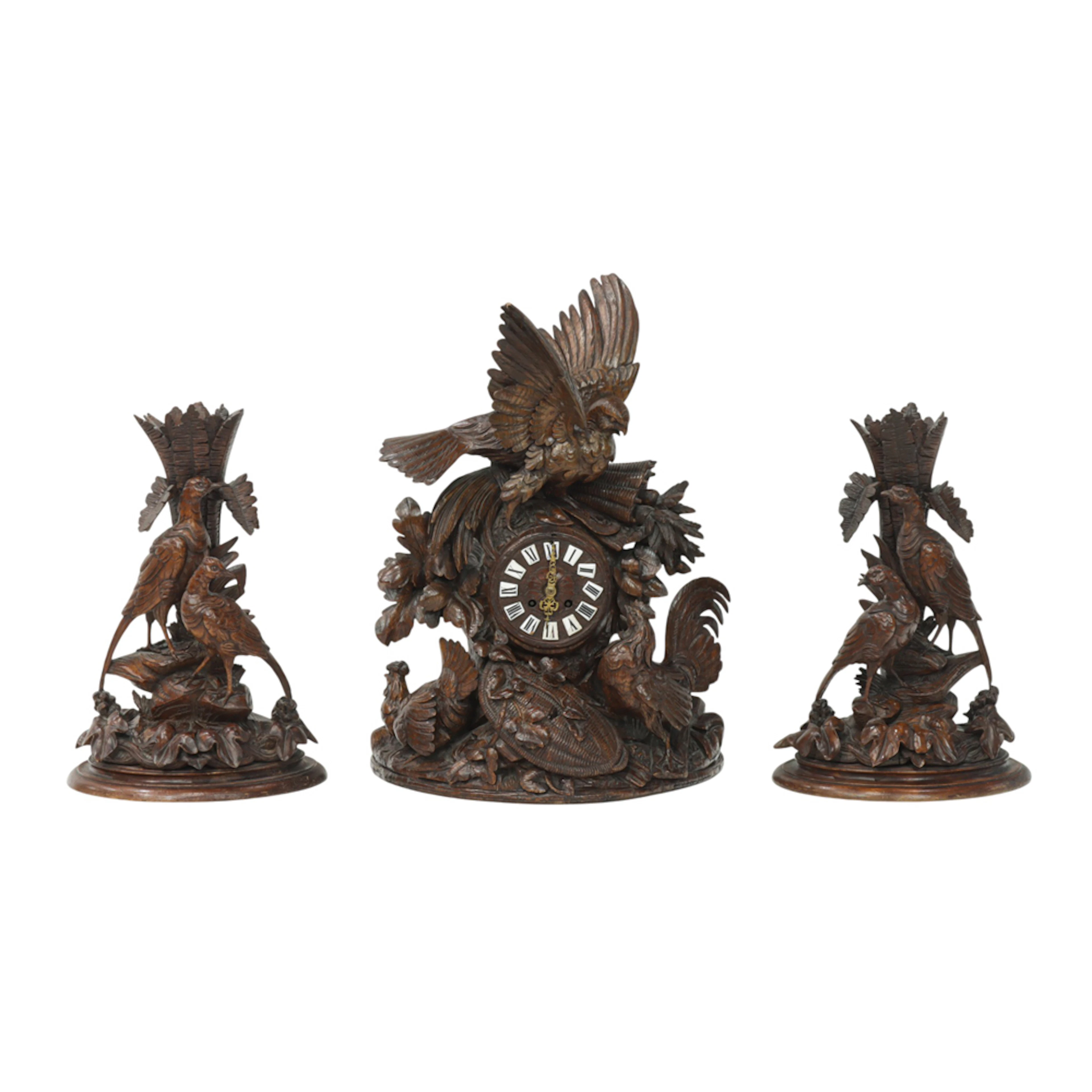 A Black Forest carved walnut clock garniture