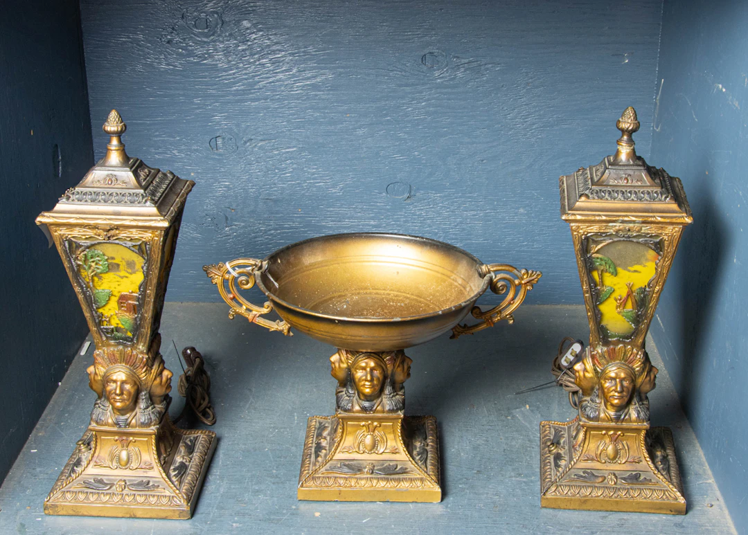 An Art Deco patinated metal and glass lamps garniture