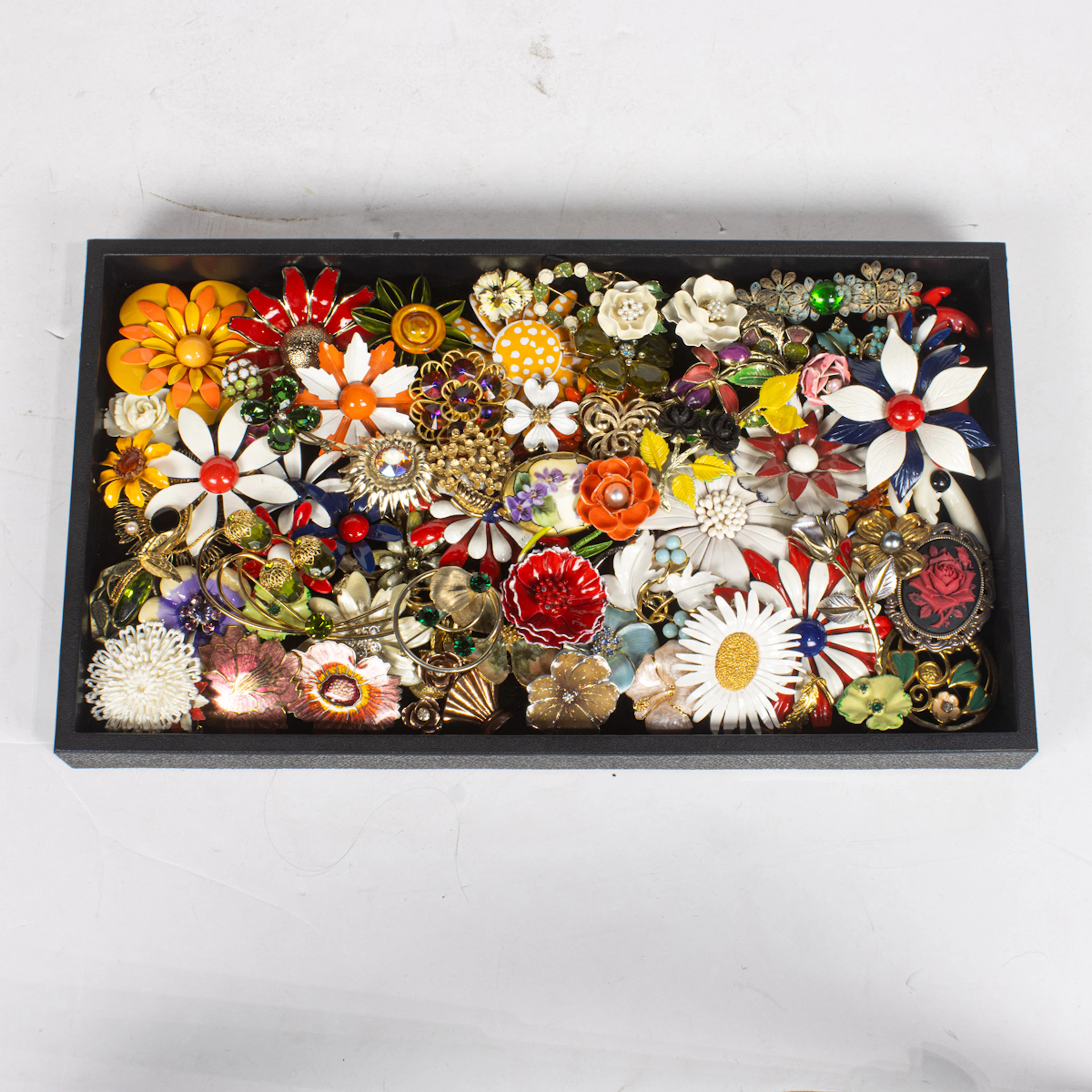 Sixty-three costume jewelry brooches of flowers, comprising Sarah