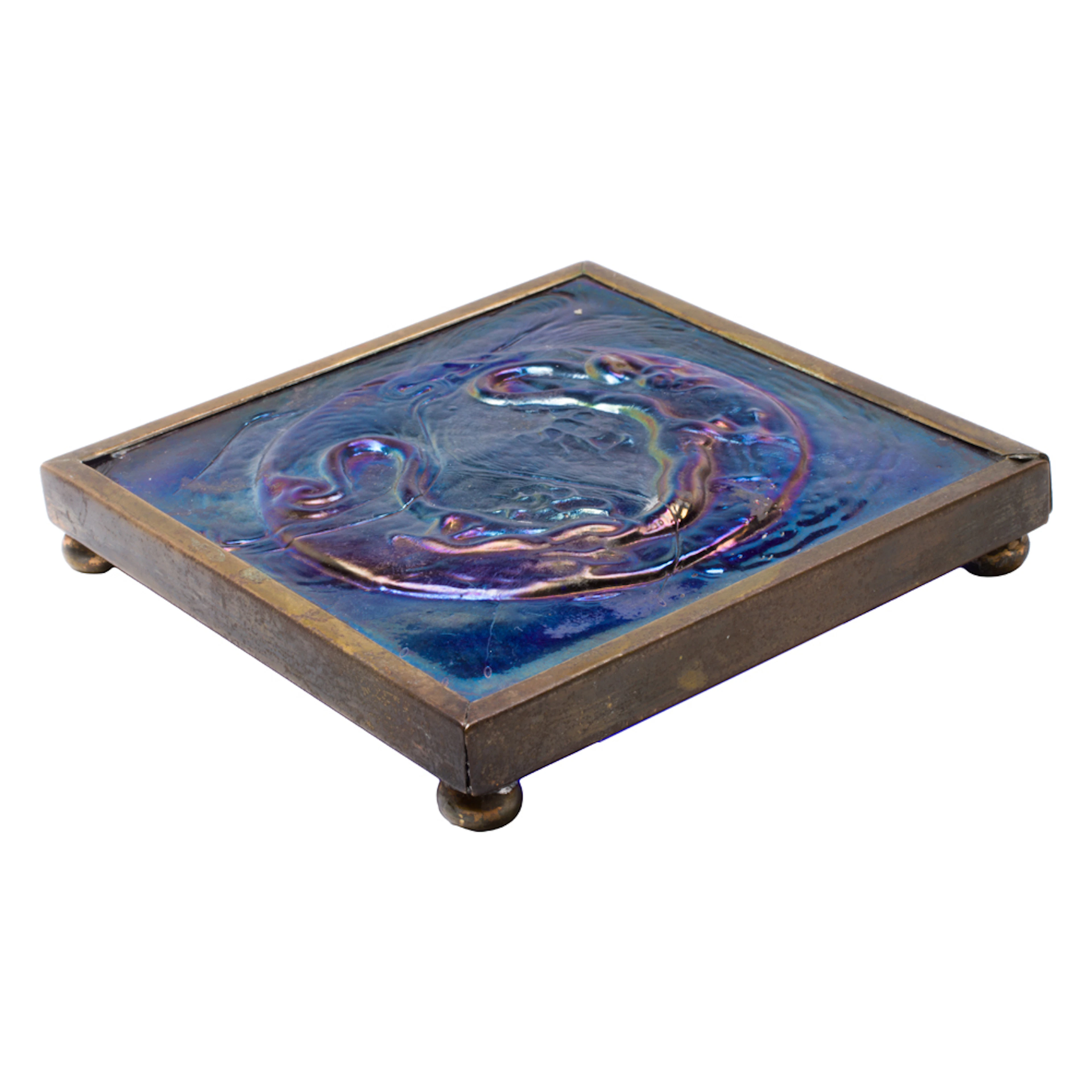 A Tiffany Furnaces bronze mounted Favrile iridescent glass Dragon tile trivet