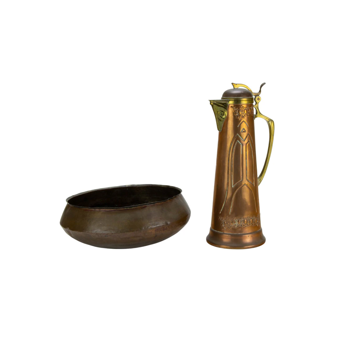 A hammered copper bowl and a German Art Nouveau brass and copper jug