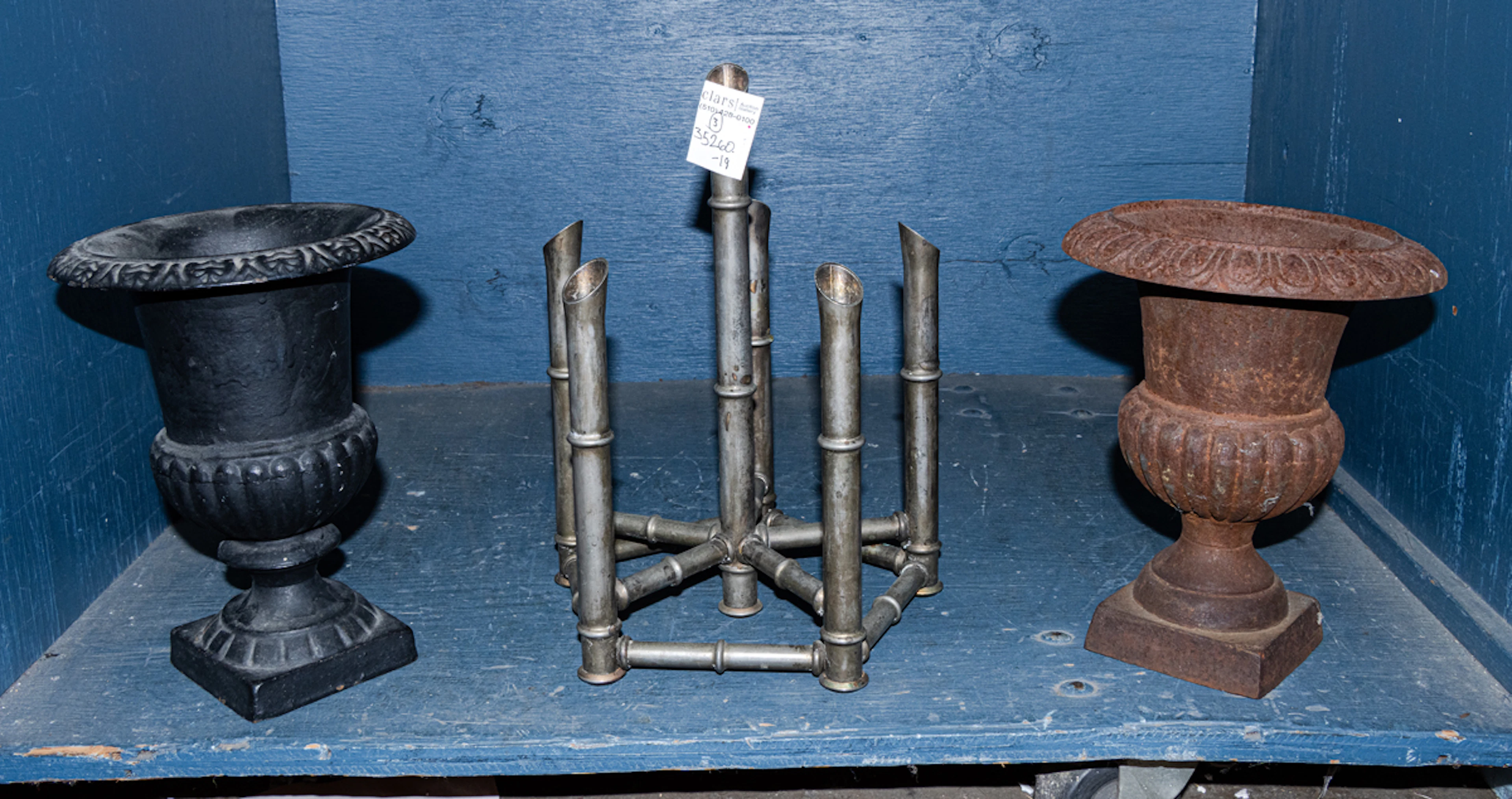 Two cast iron campana form urns and a silver-plated faux bamboo candle stand