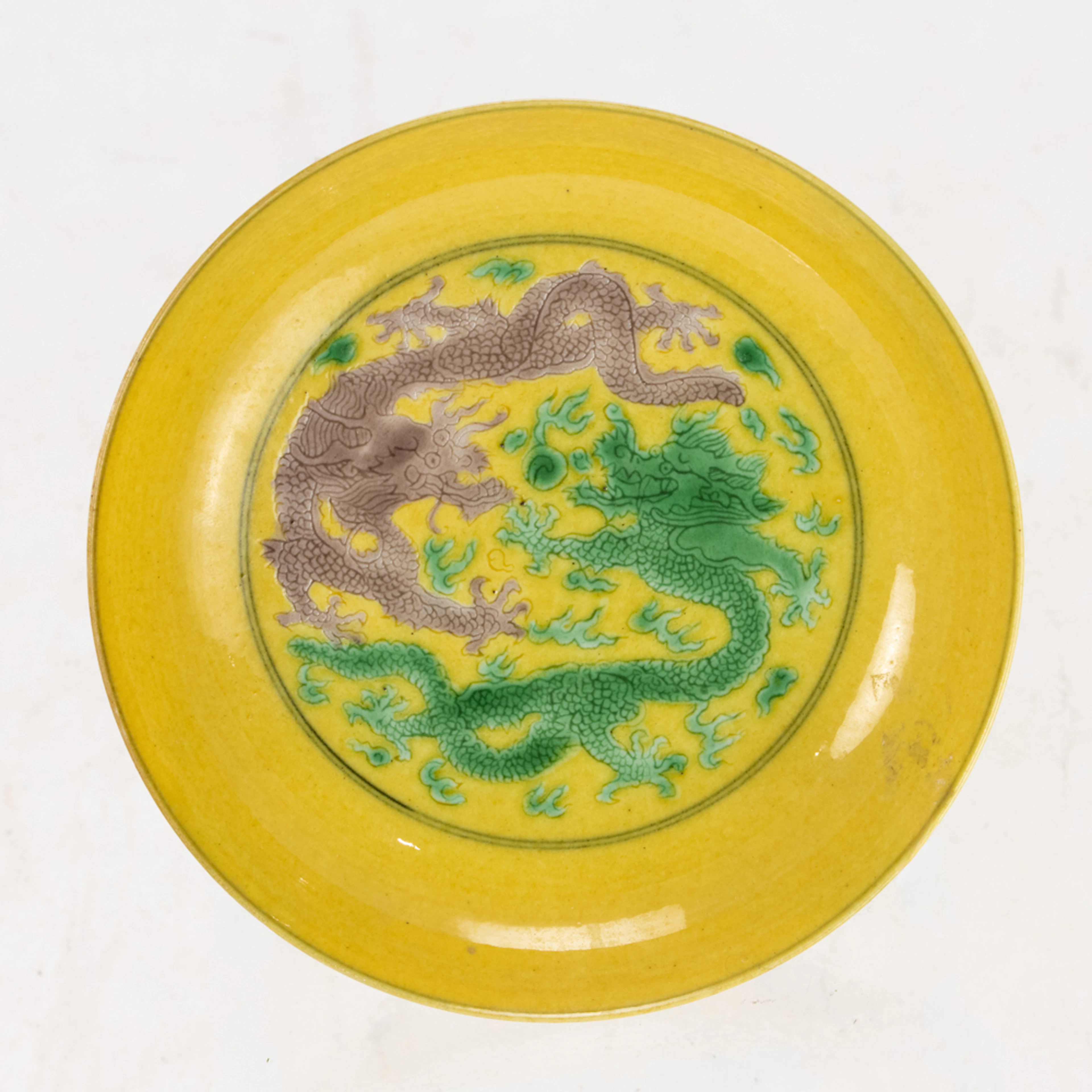 A Chinese yellow ground green and aubergine glazed dragon dish
