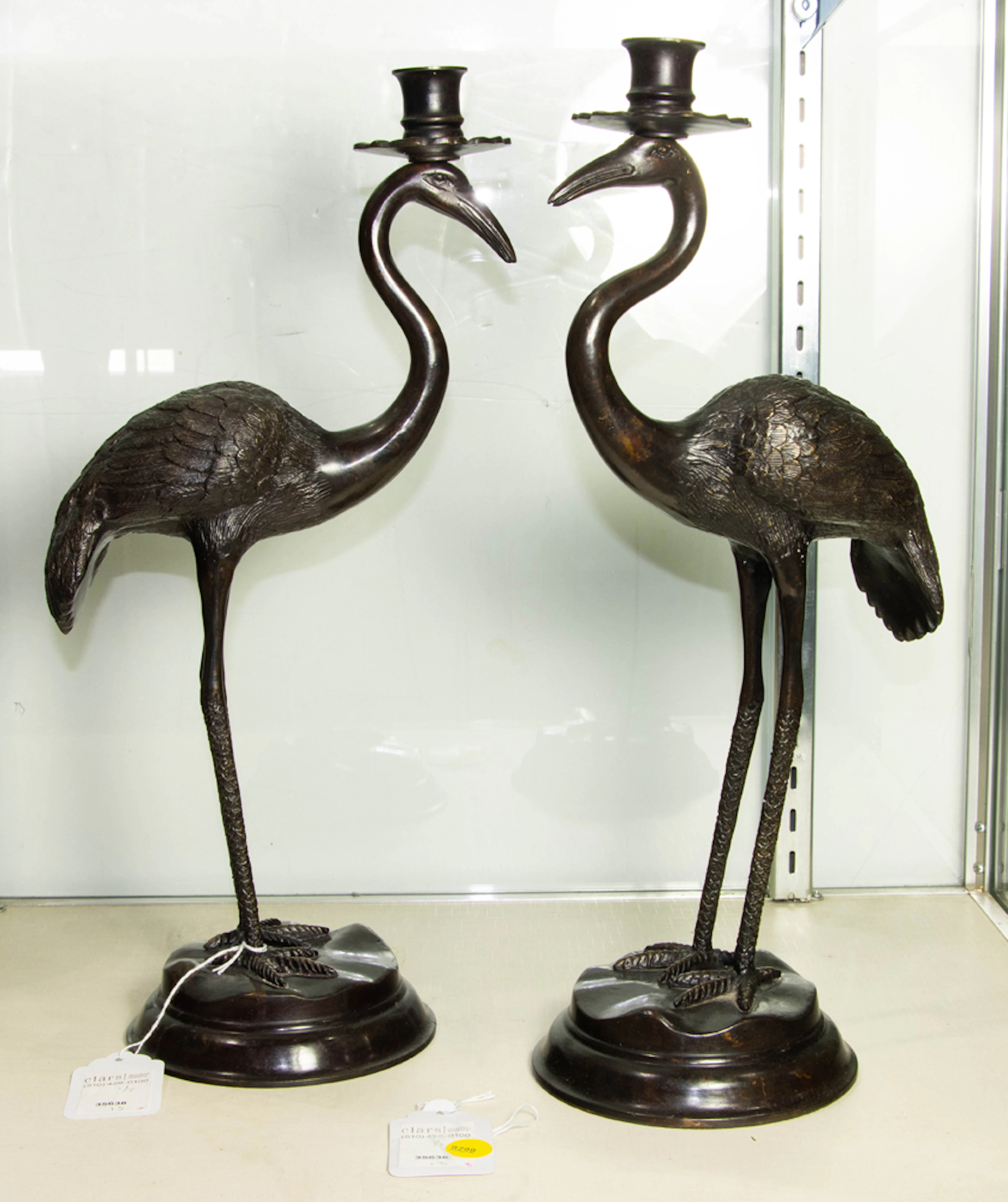 A pair of patinated bronze crane form candlesticks in the Japanese taste