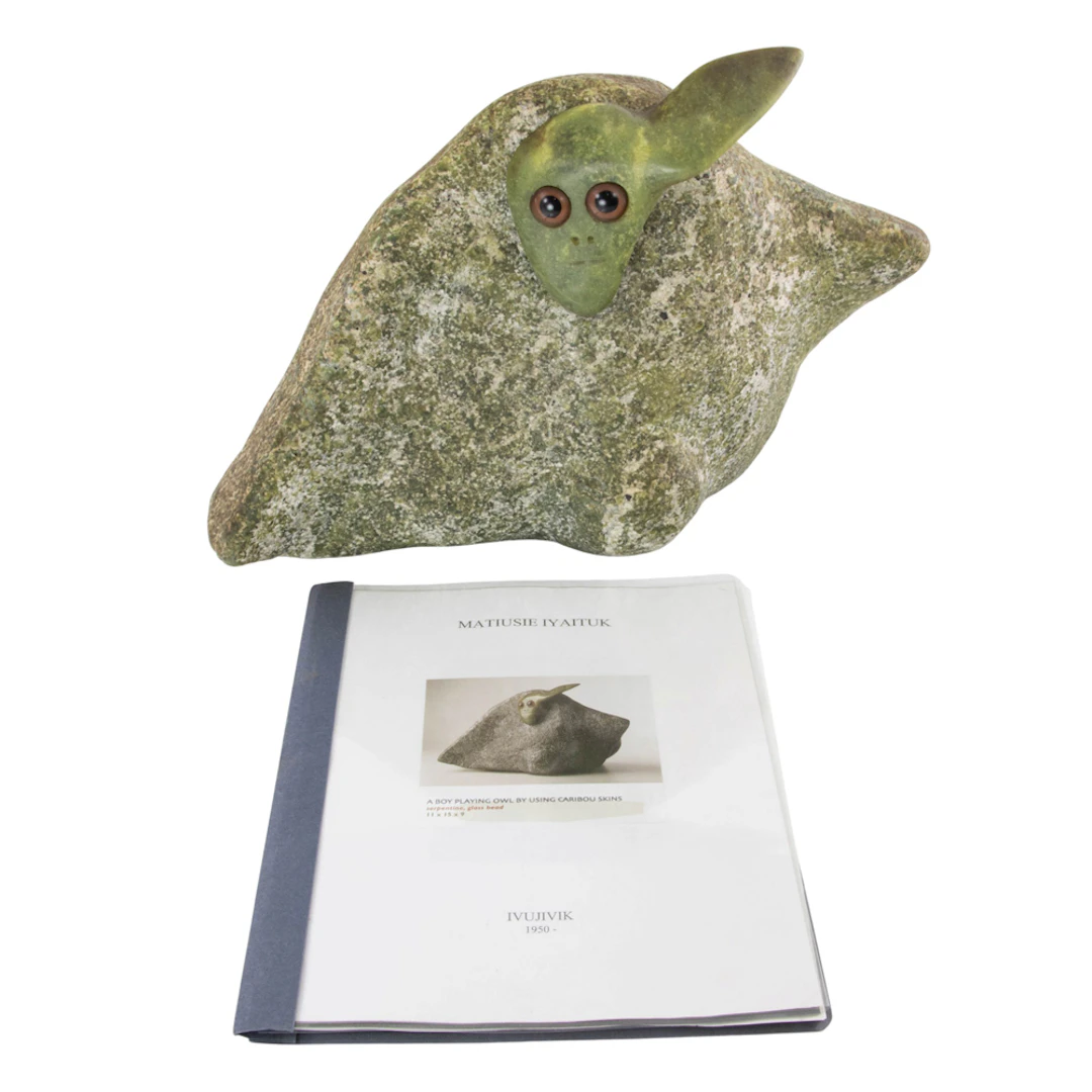An Inuit serpentine stone figure: A Boy Playing Owl by Using Caribou Skins