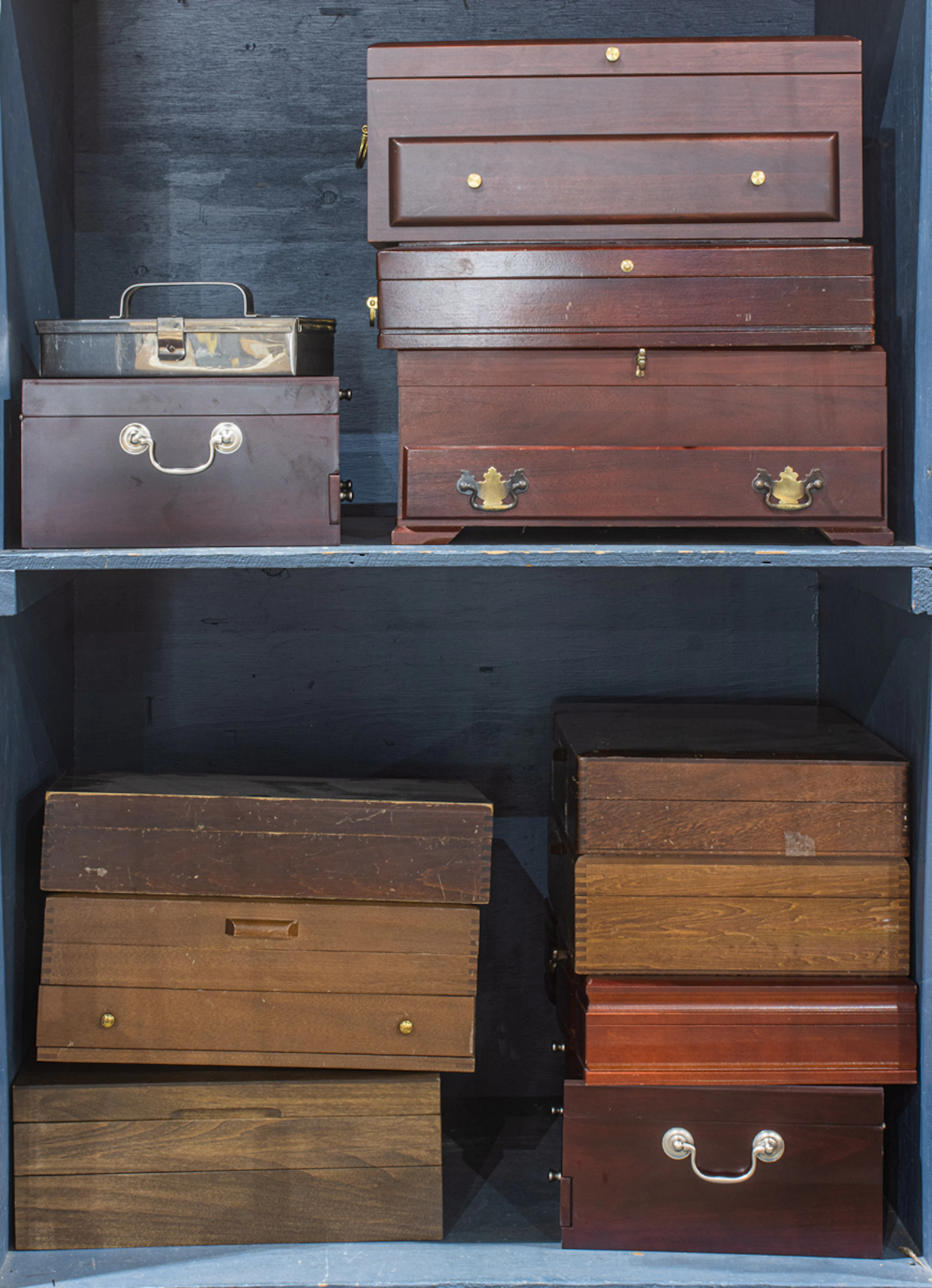 A group of eleven silverware canteens and a metal box
