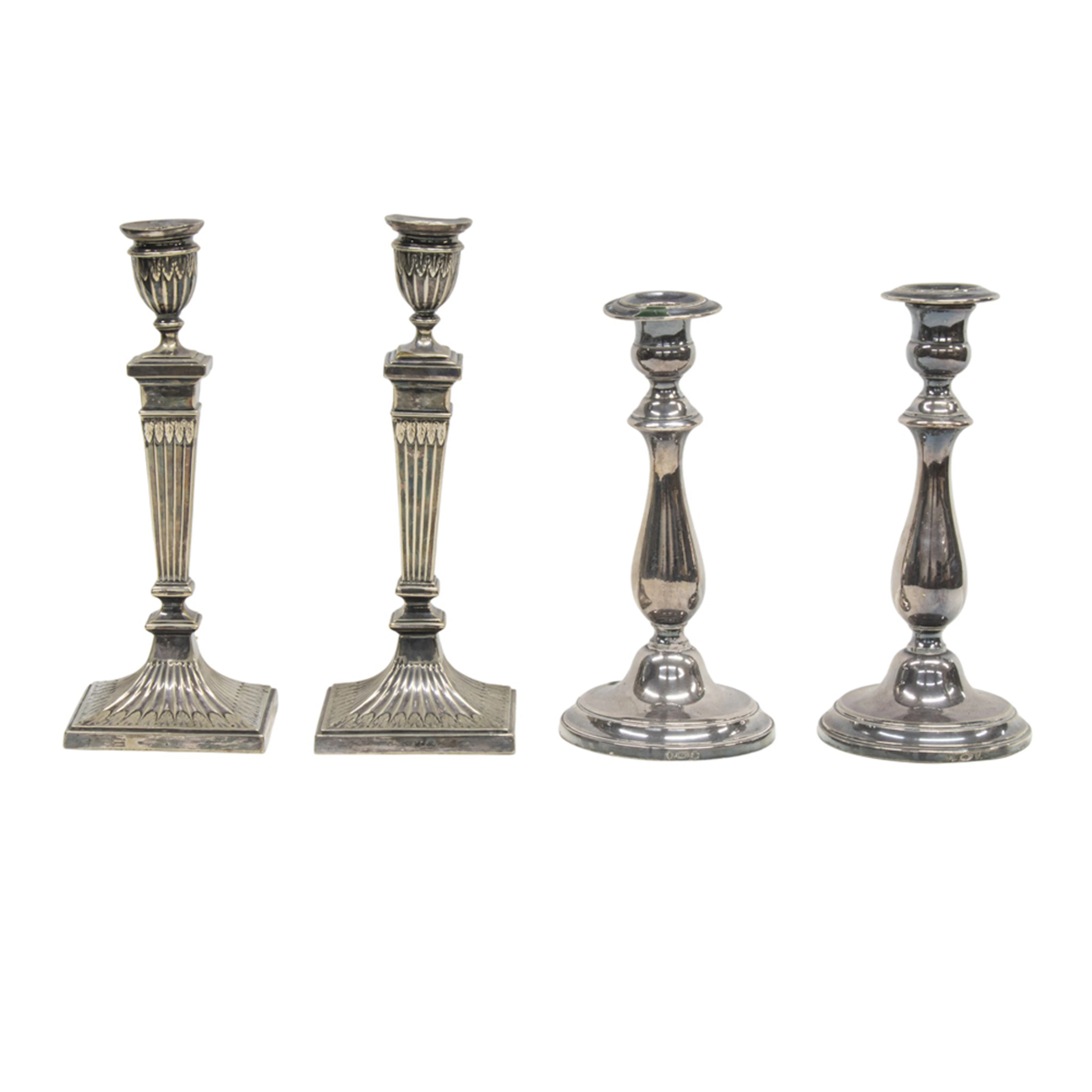 A silver plated group of two pairs of candlesticks