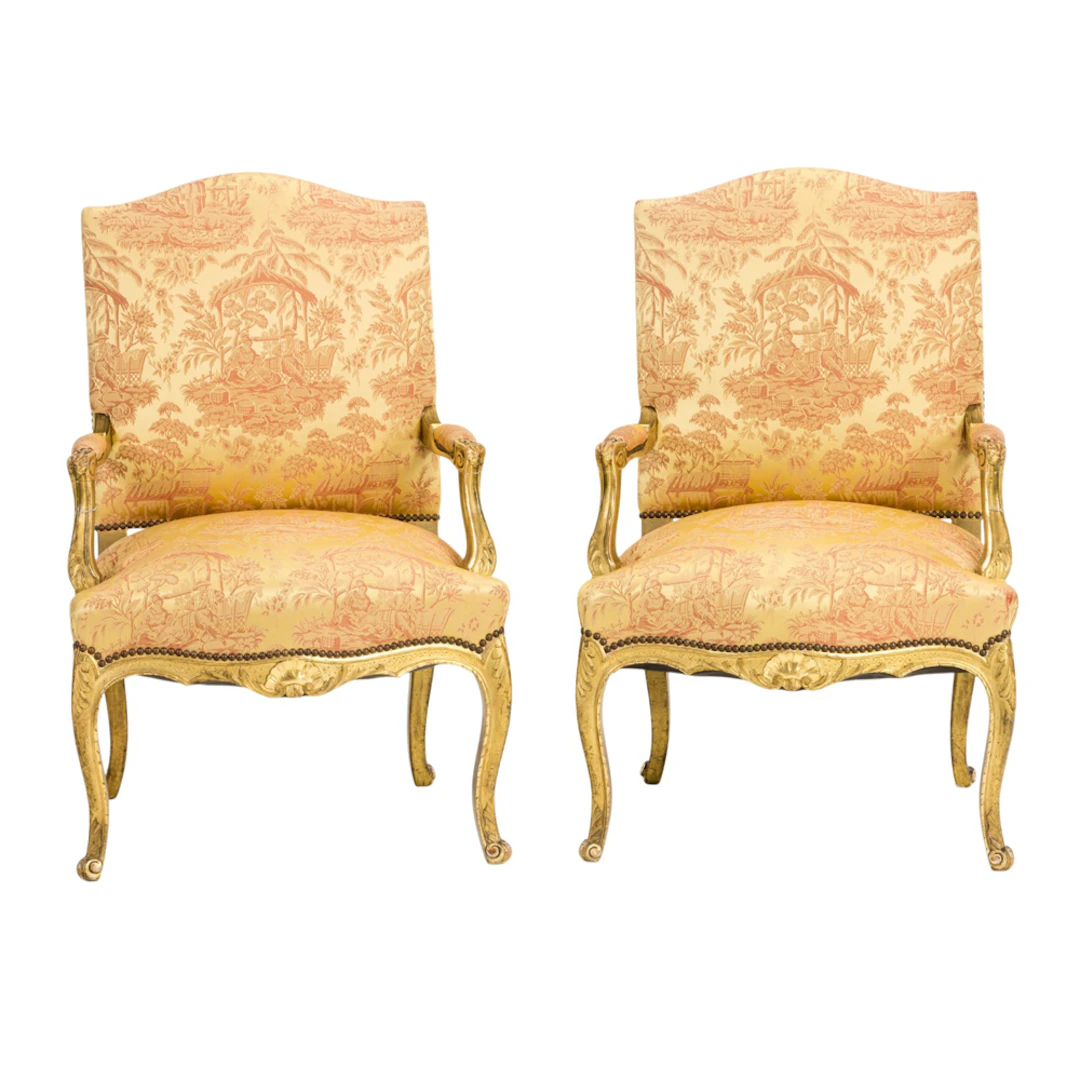 A pair of Louis XV style giltwood carved armchairs or fauteuils