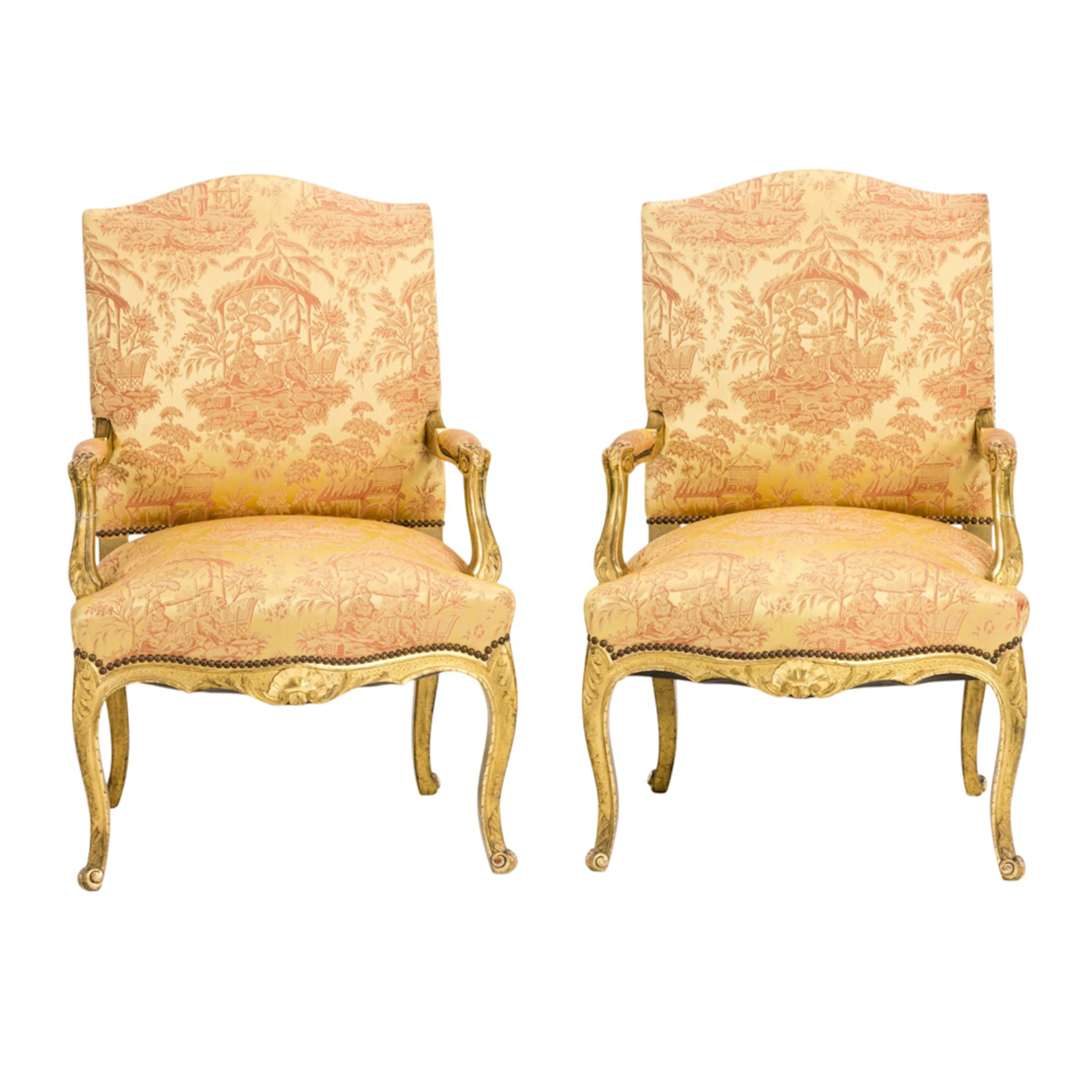 A pair of Louis XV style giltwood carved armchairs or fauteuils