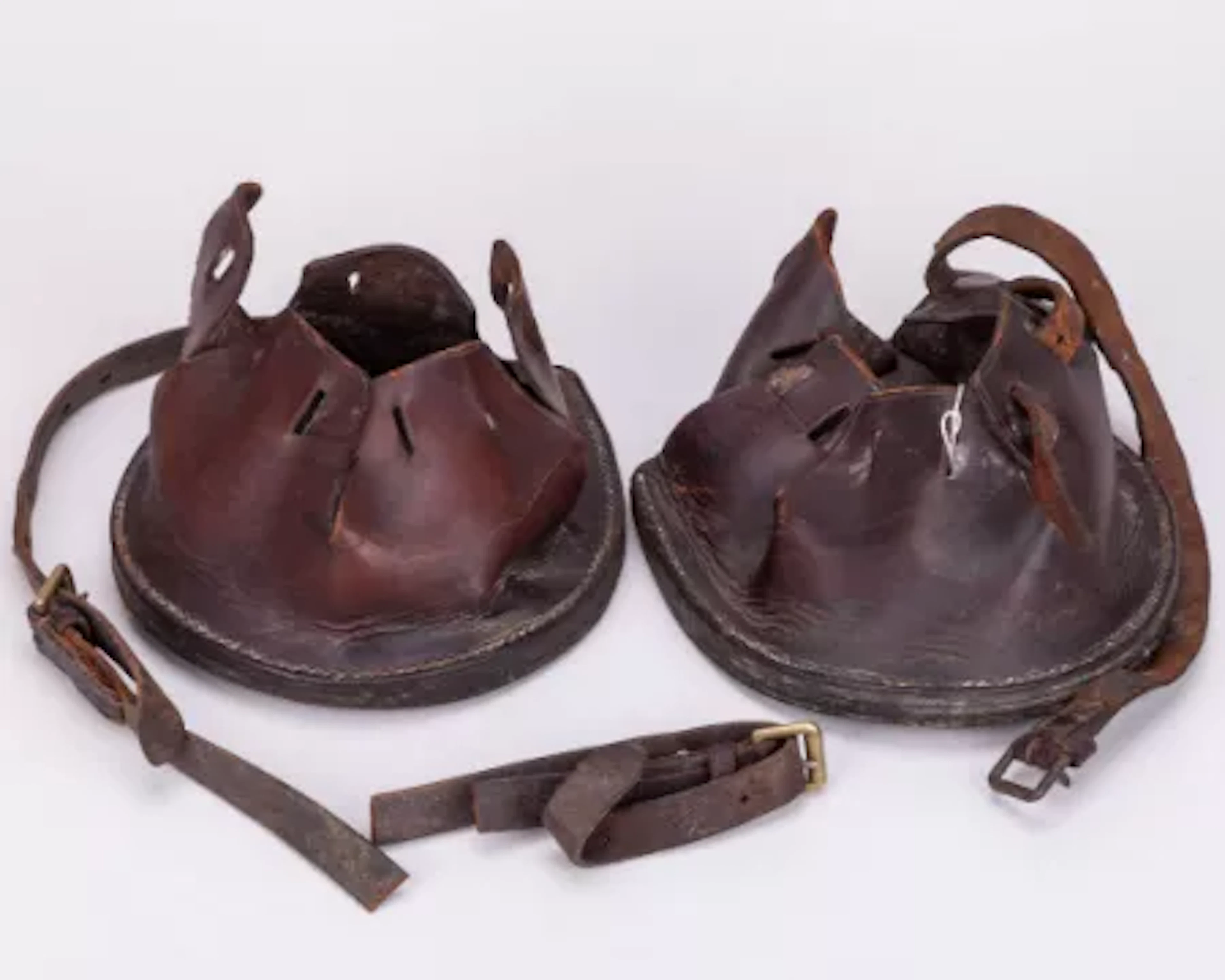 A pair of leather horse hoof lawn boots used for pulling heavy lawn