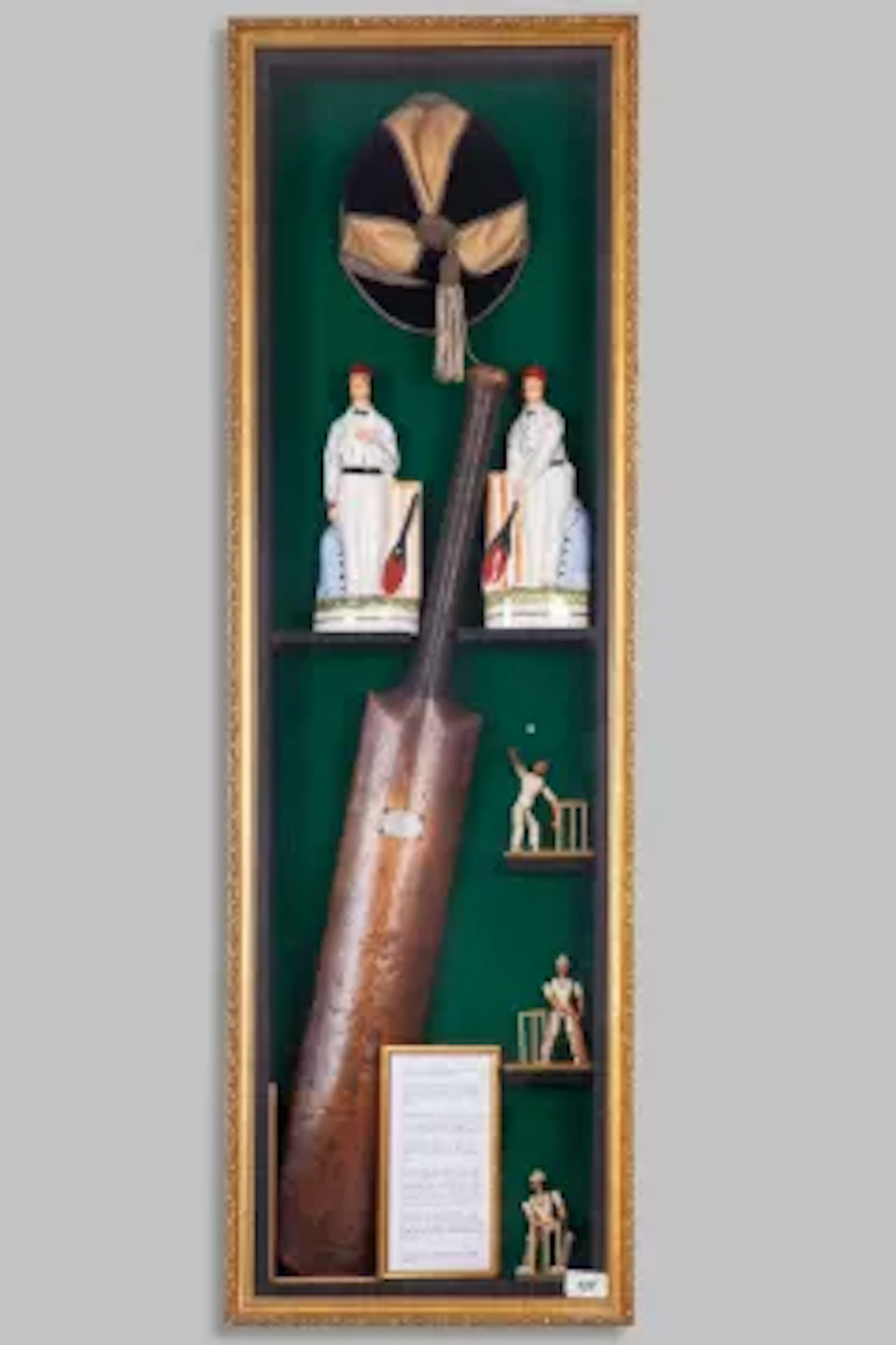 A cricket memorabilia display case, containing a Victorian cricket bat