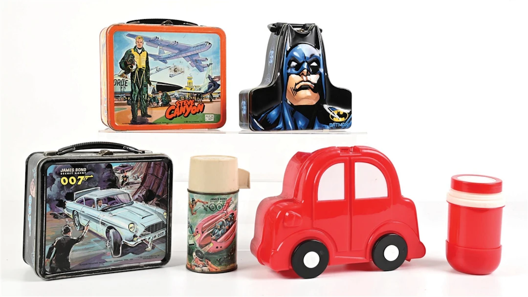 LOT OF 4: JAMES BOND 007, STEVE CANYON, RED PLASTIC CAR, AND BATMAN LUNCHBOXES