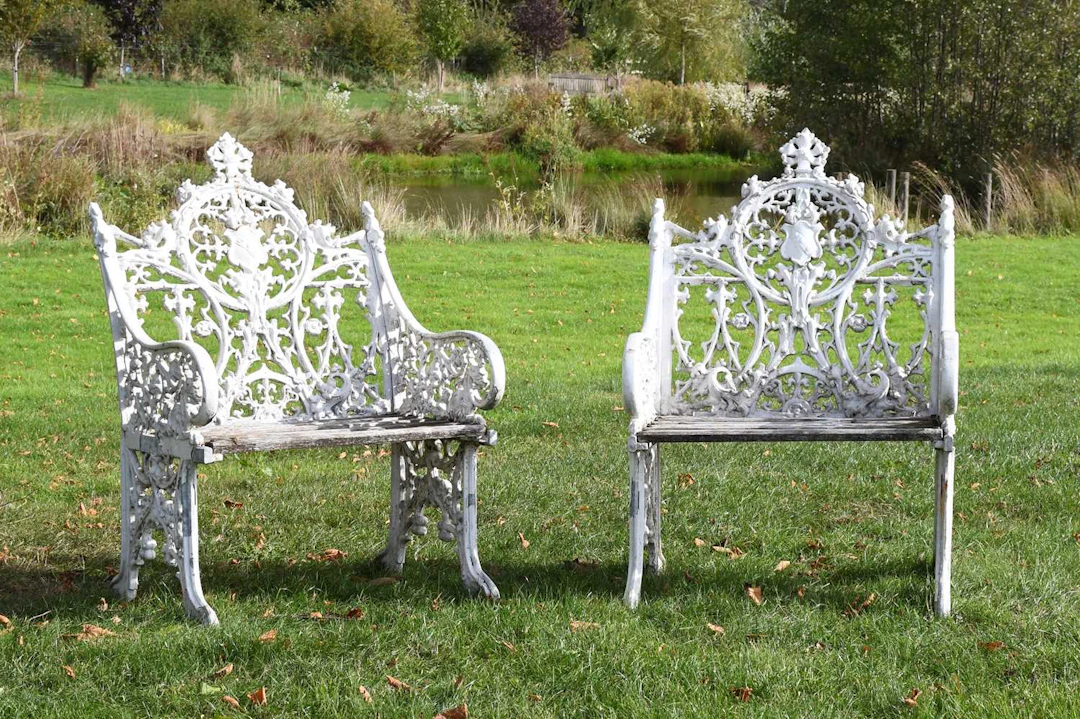 A Pair of Cast Metal and White Painted Bartholomew-Style Garden Seats