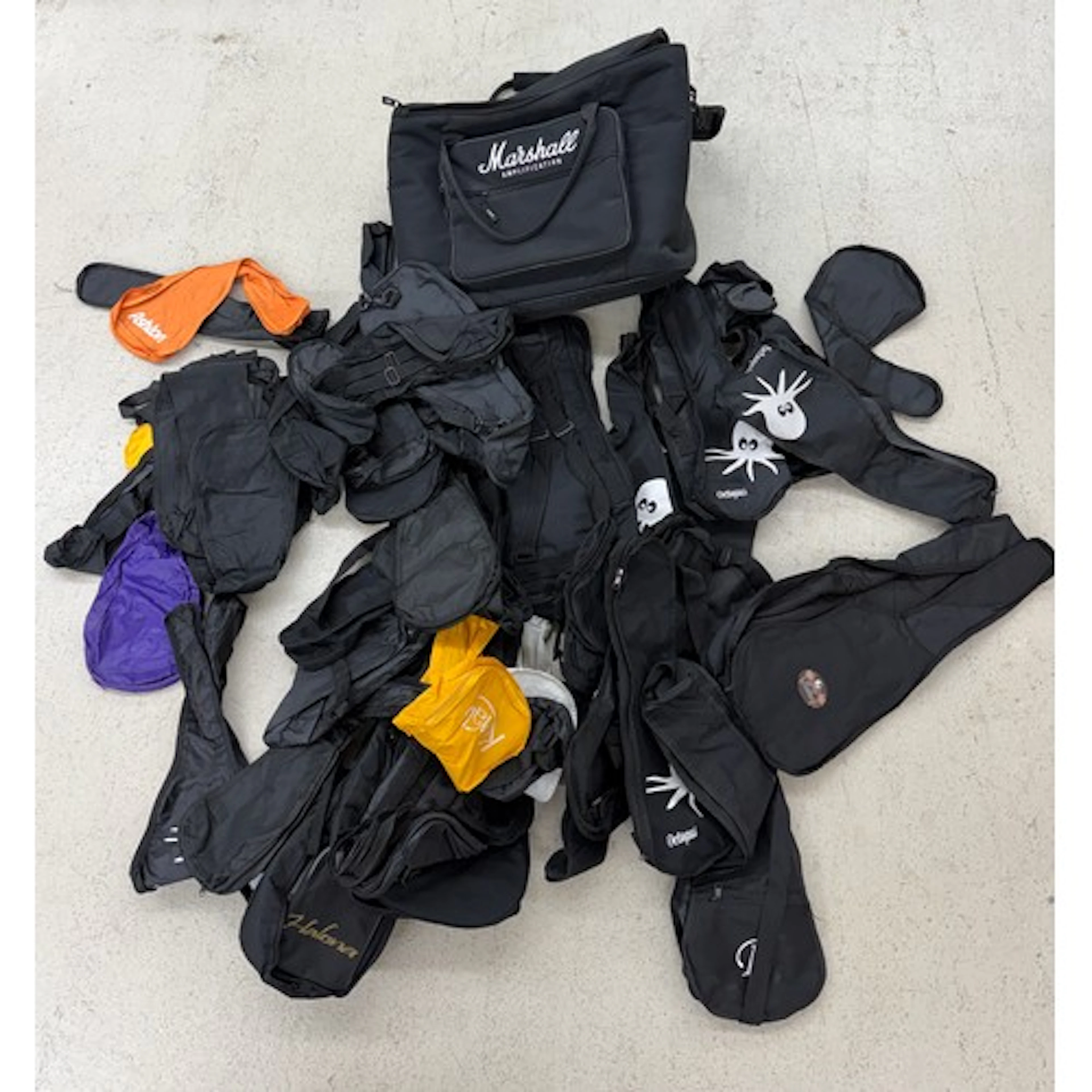 Approximately forty ukulele soft cases, within a Marshall Am...