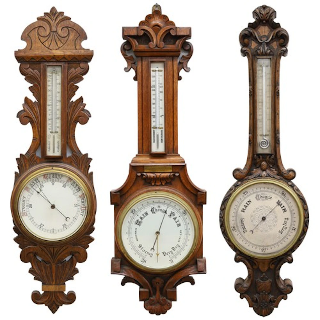 Group of three oak aneroid barometers, each with foliate car...
