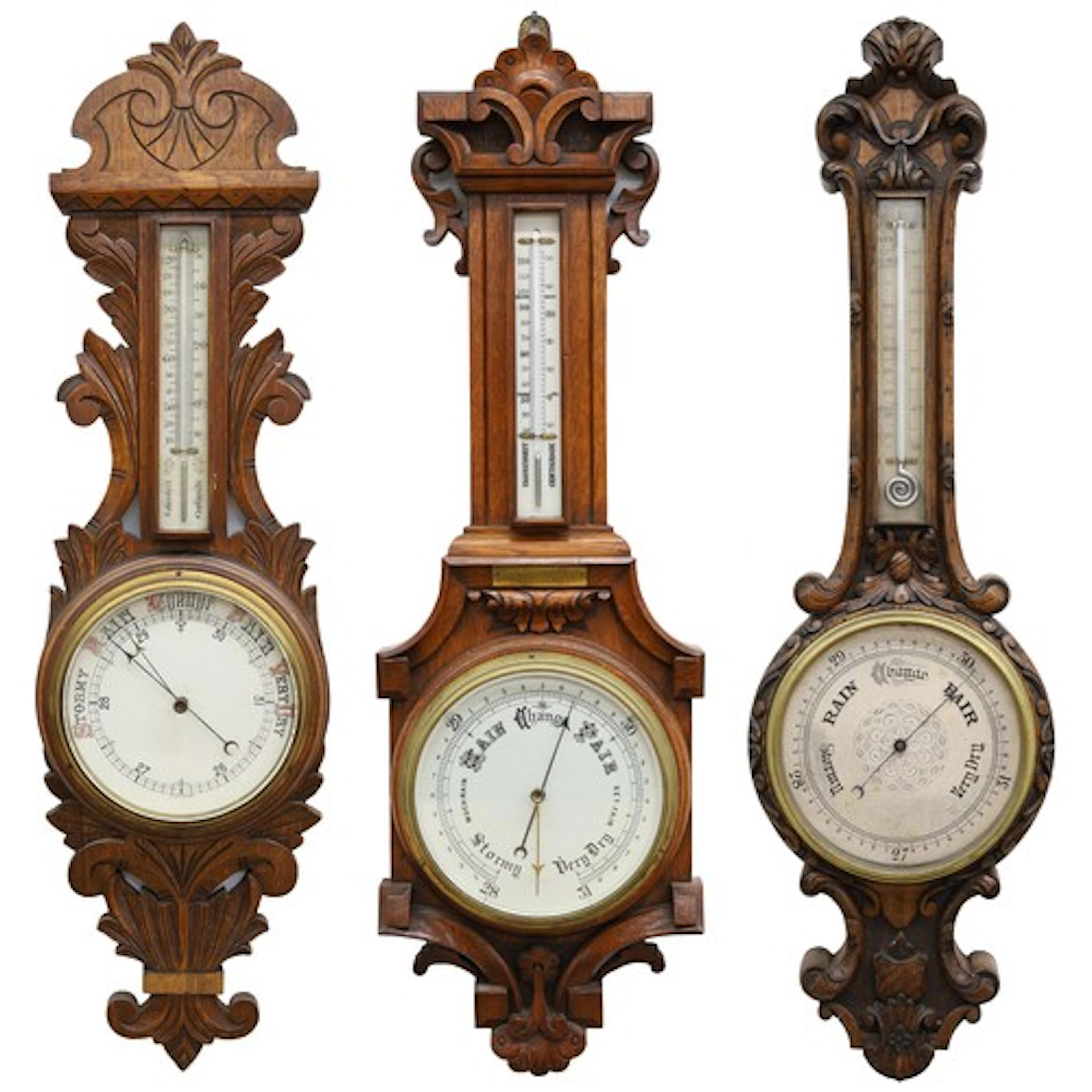 Group of three oak aneroid barometers, each with foliate car...