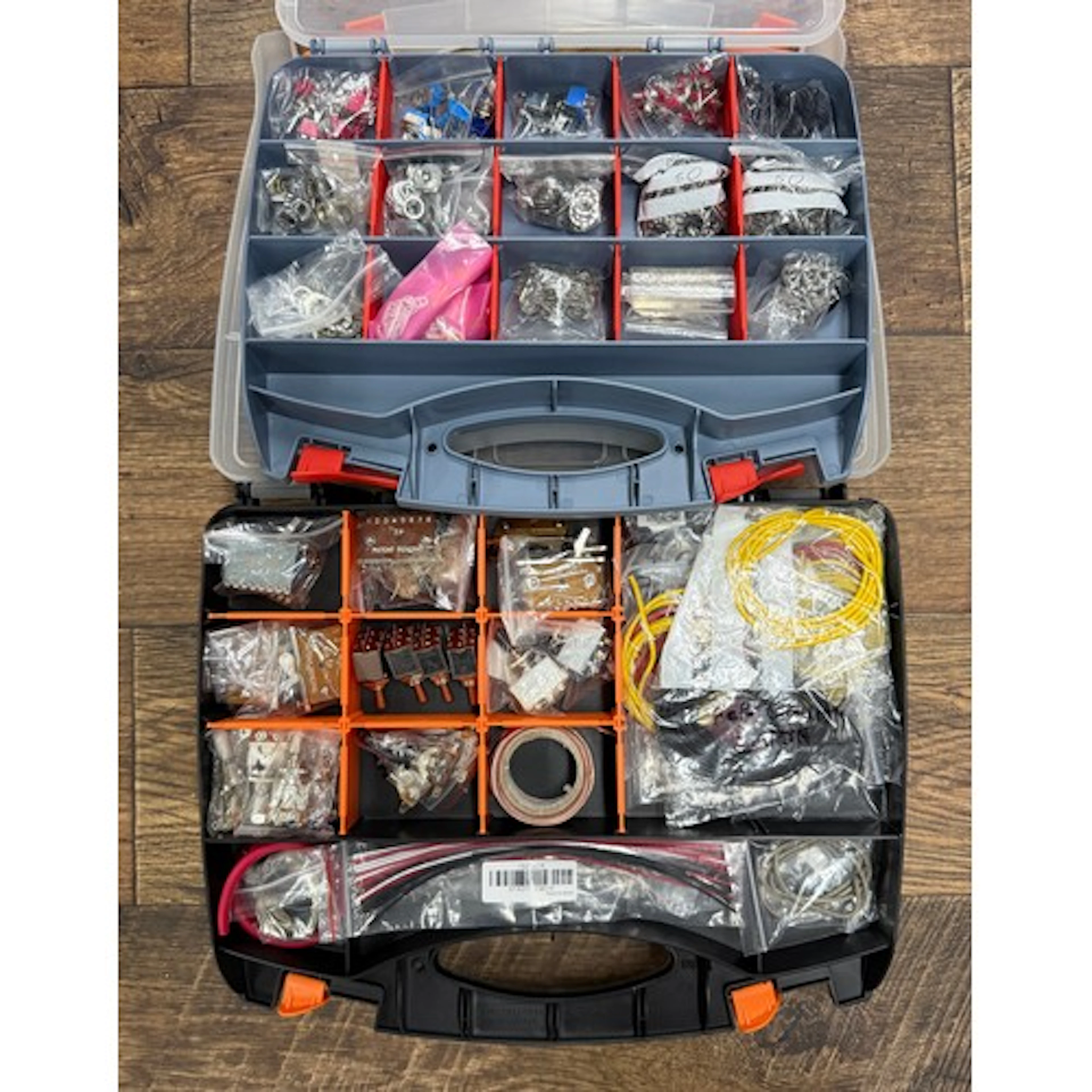 Two double-sided plastic organiser boxes containing guitar e...