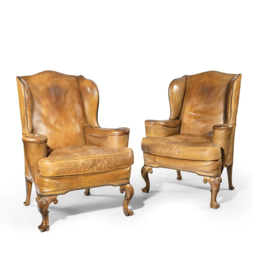 A pair of walnut wing armchairs in the Queen Anne style