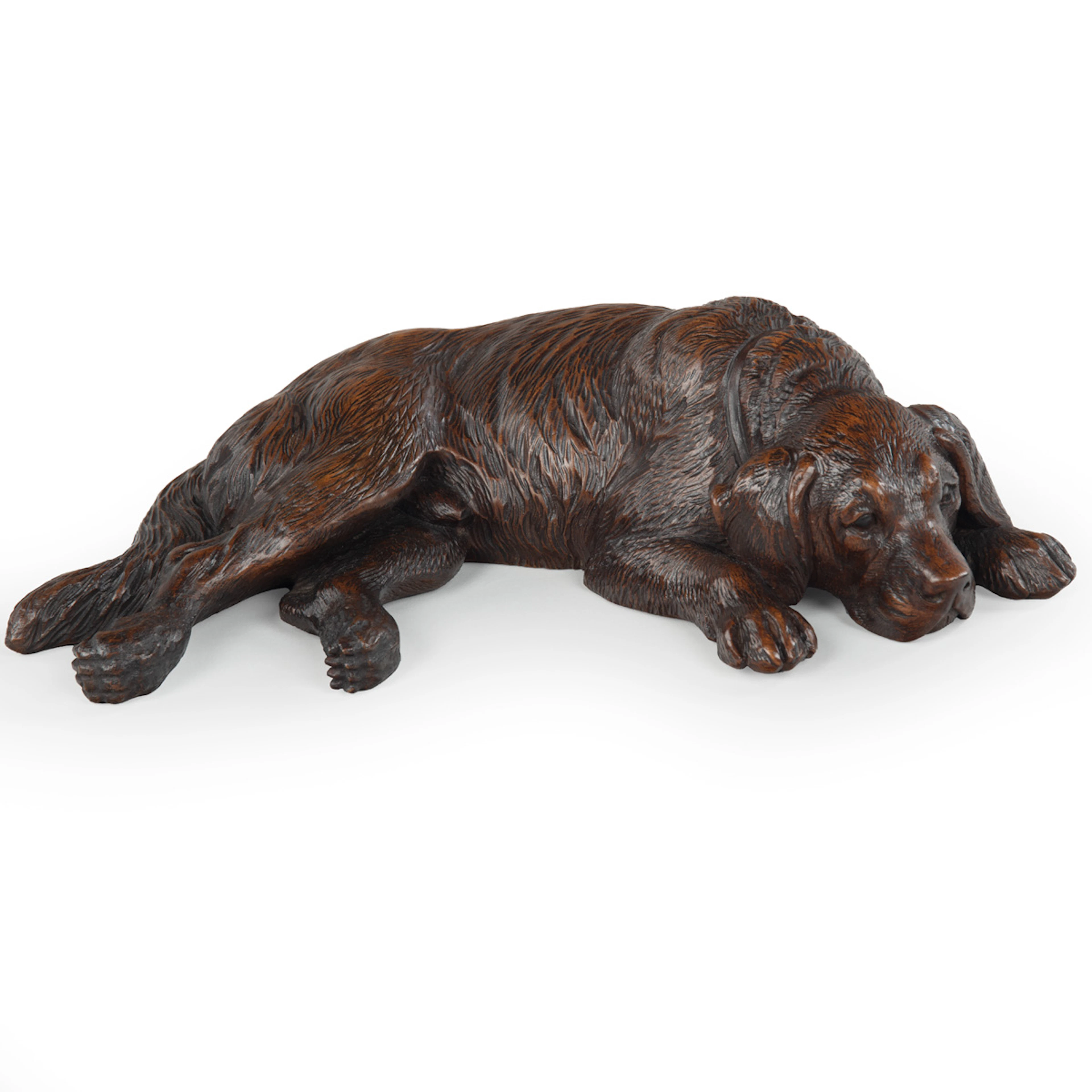 A charming Swiss Black Forest Carved St. Bernard dog relaxed lying