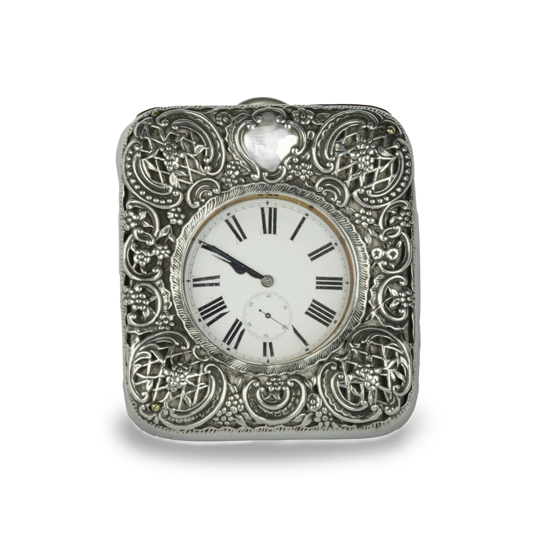 An Edwardian silver watch set into a repousse silver case